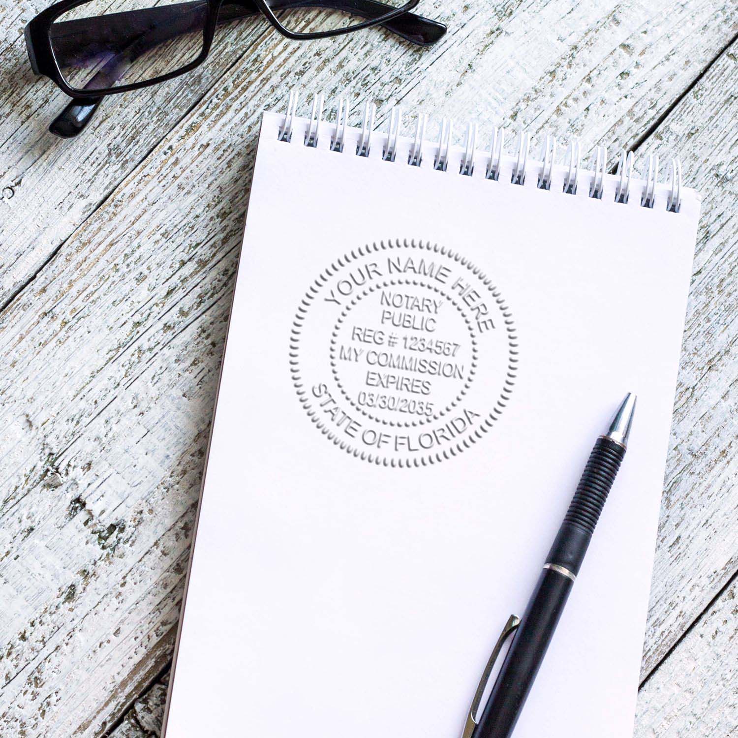 A round Florida Notary Seal image on a notepad with a pen and a spectacle