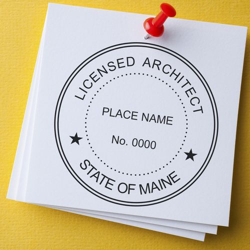 Licensed Architect State of Maine seal stamp on white paper with a red pushpin. Blog post: Maine Architecture Seal Stamps.