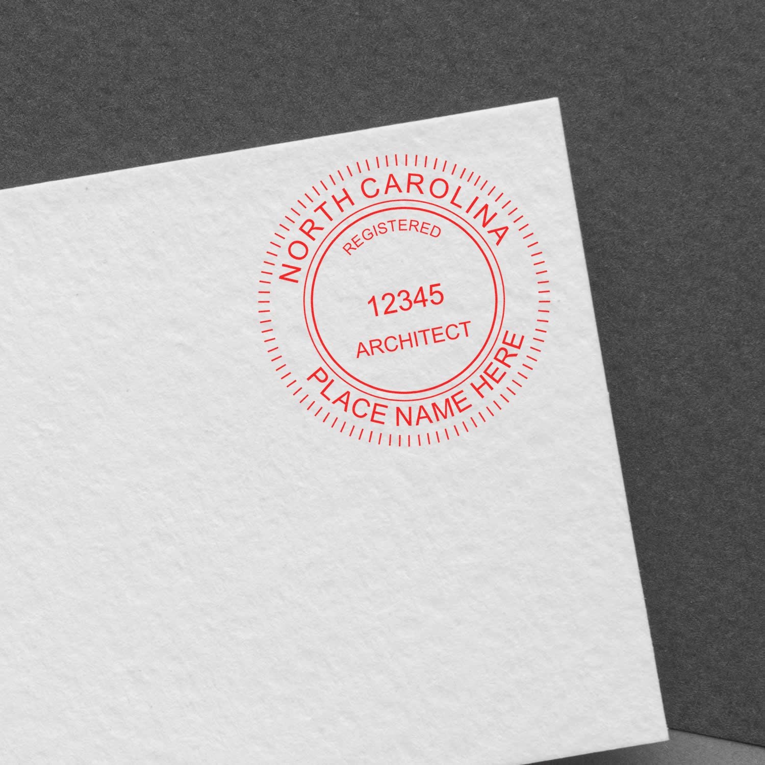 Architectural Seal Stamp blog post: A red North Carolina architect seal stamp on white paper with the text REGISTERED 12345 ARCHITECT PLACE NAME HERE.