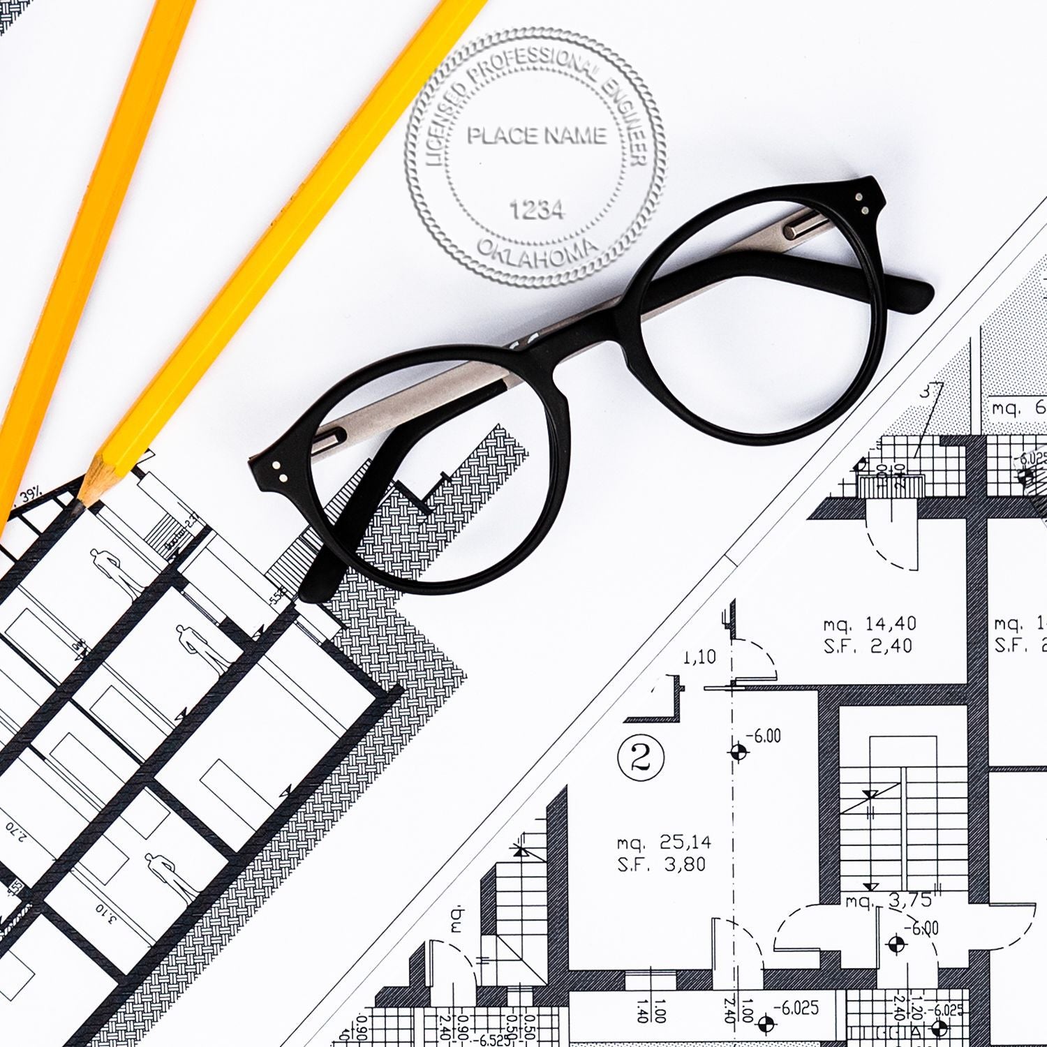 Oklahoma Engineer Seal blog post: An engineer's desk with architectural plans, a pair of glasses, pencils, and an Oklahoma engineer seal.