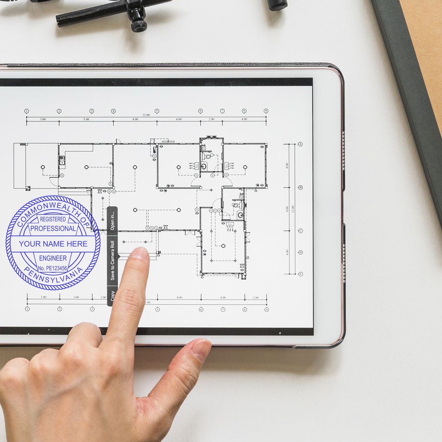 Engineer pointing at a floor plan on a tablet with the Pennsylvania Seal. Blog post: Pennsylvania Seal.