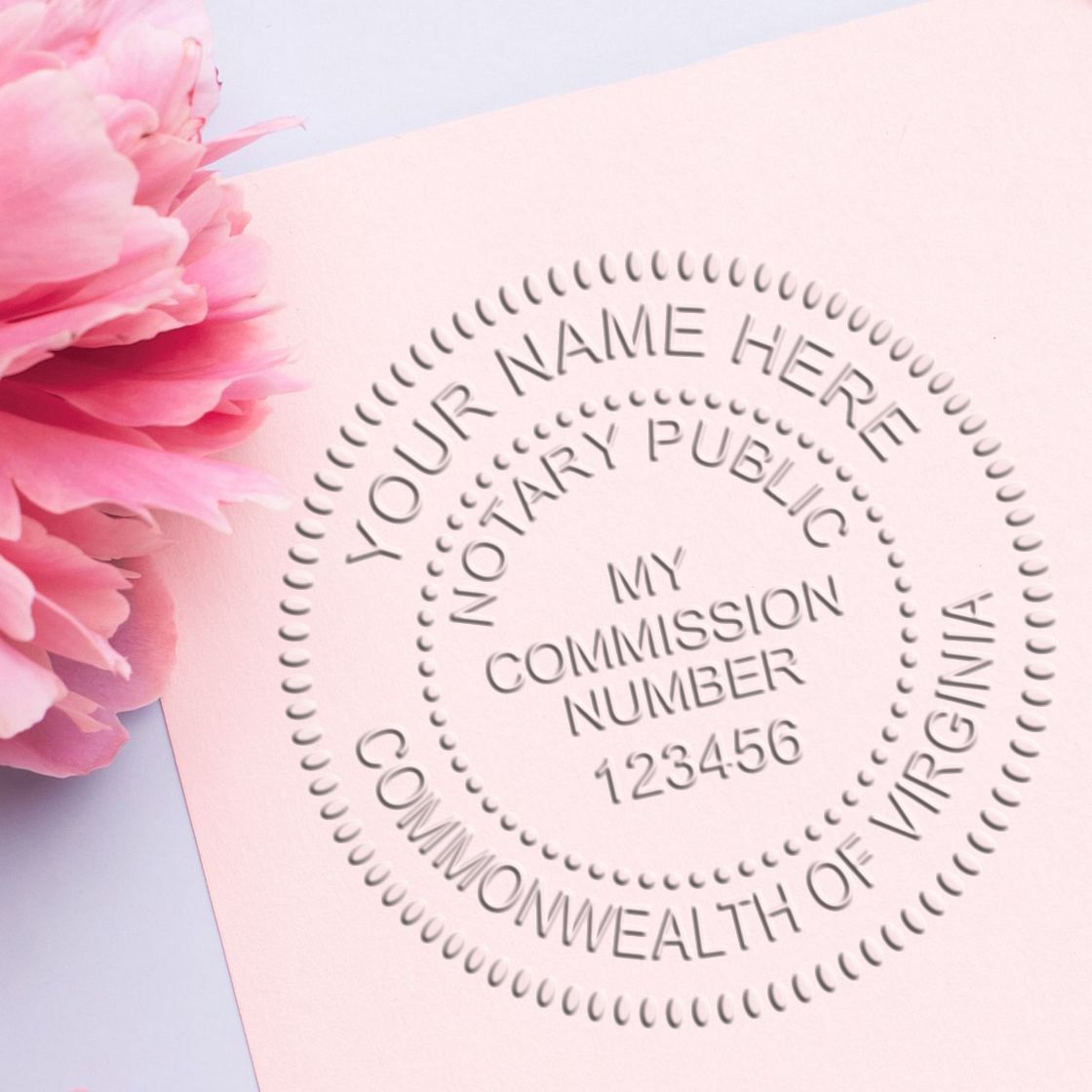Expiring Notary Seals: What You Need to Know Feature Image - Close-up of a Virginia notary seal on pink paper with a pink flower.