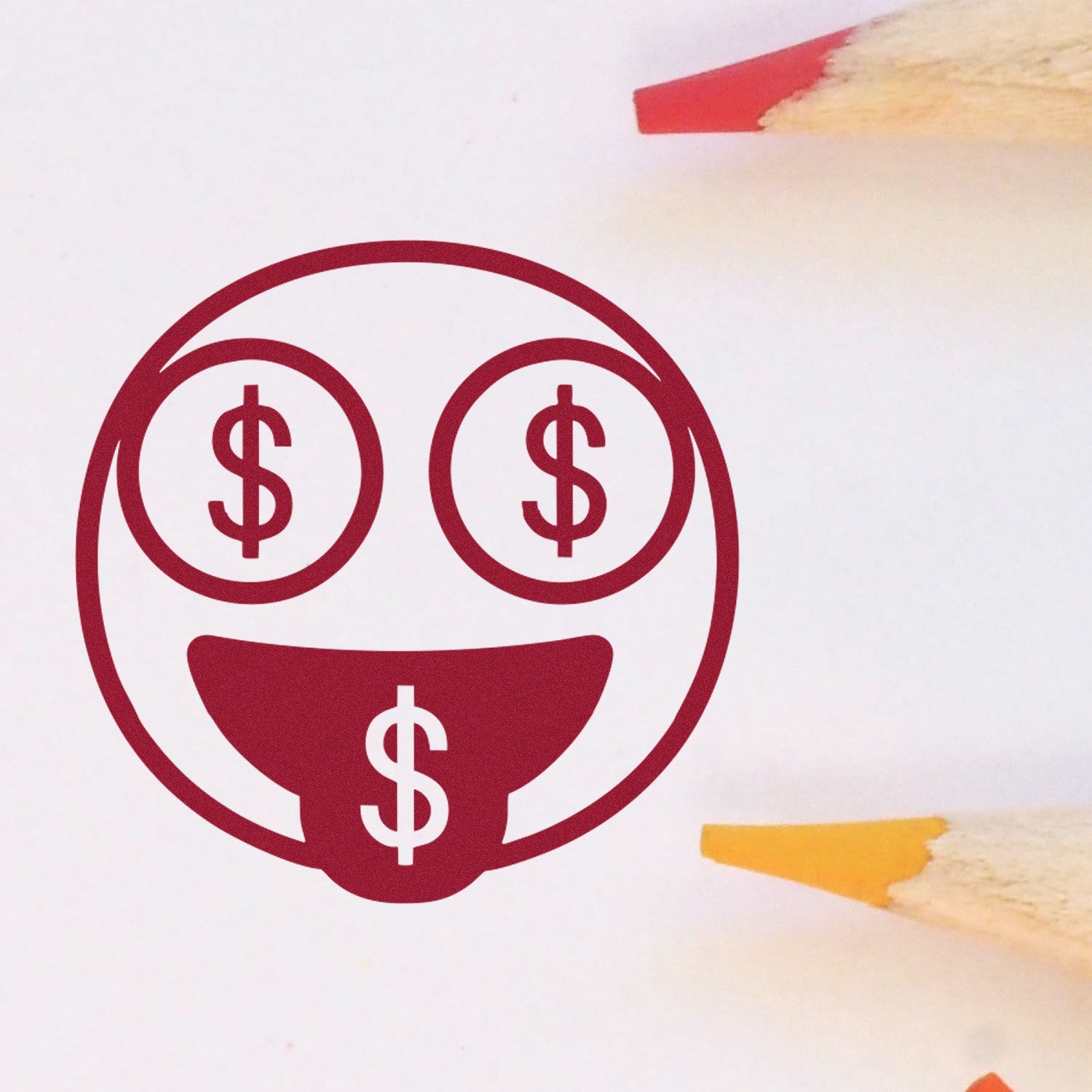 Self-Inking Money Eyes Facial Expressions Stamp featuring a smiling face with dollar signs for eyes and tongue, surrounded by colored pencils. Perfect for adding fun to documents and crafts.