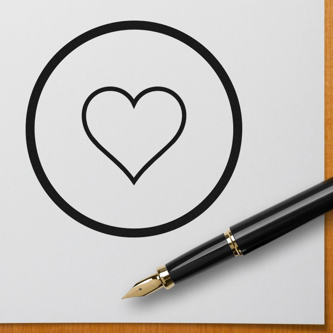 Self-Inking Heart of Simplicity Emojicons Stamp on white paper, featuring a black heart design within a circle. Perfect for adding a personal touch to stationery and crafts.