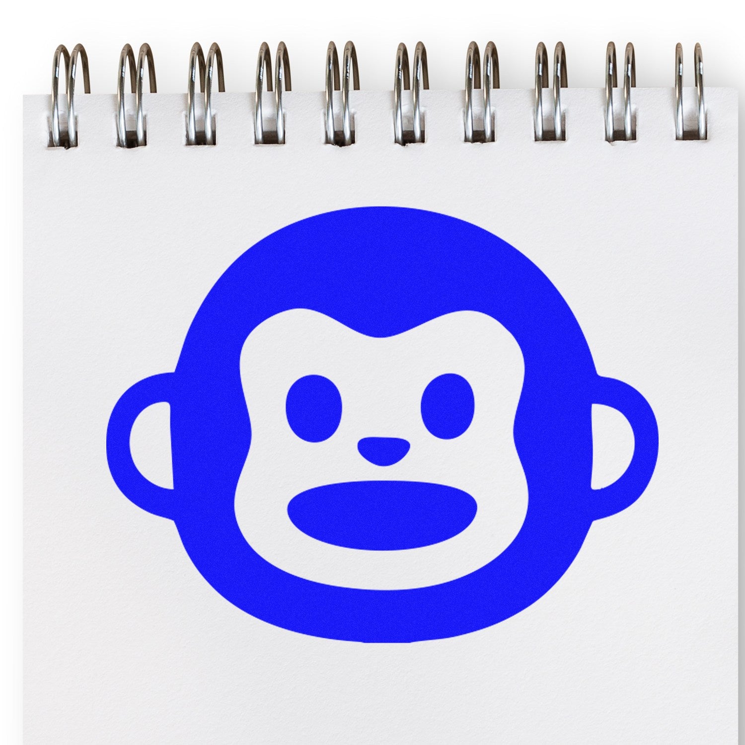 Wood Handle Monkey Marvel Reaction Rubber Stamp featuring a blue monkey face design on a white notepad, showcasing its unique and playful imprint. Perfect for creative projects and stationery.