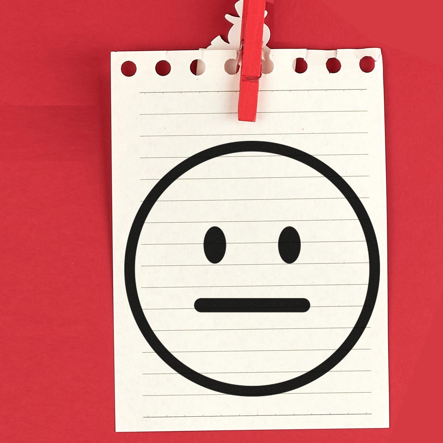 Self-Inking Neutral Ned Emoji Stamp on lined paper, featuring a neutral face emoji. Perfect for adding a fun, expressive touch to notes and documents.