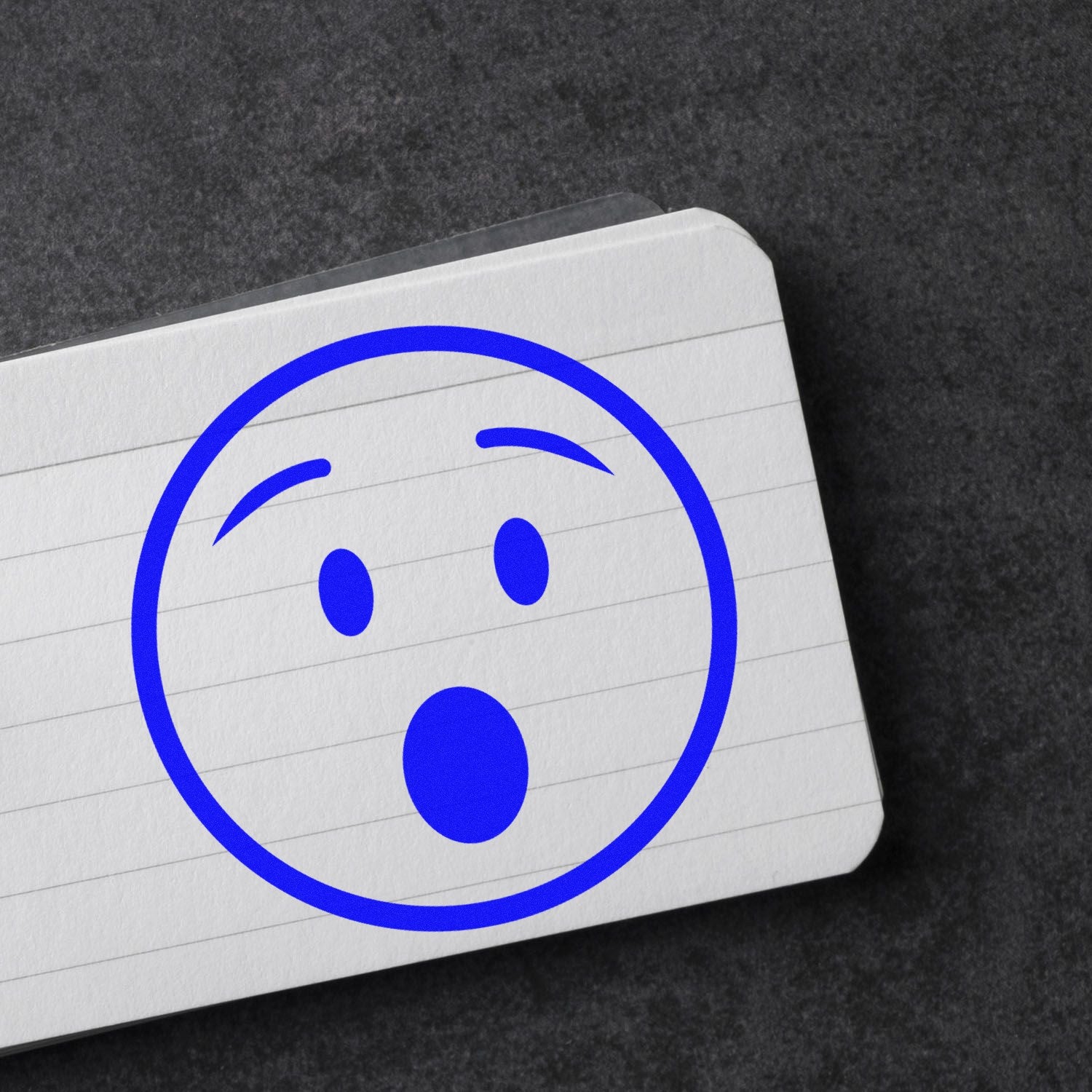 Self-Inking Amazed Andy Emotes Stamp featuring a surprised blue face on a lined notepad, perfect for adding expressive flair to documents and crafts.