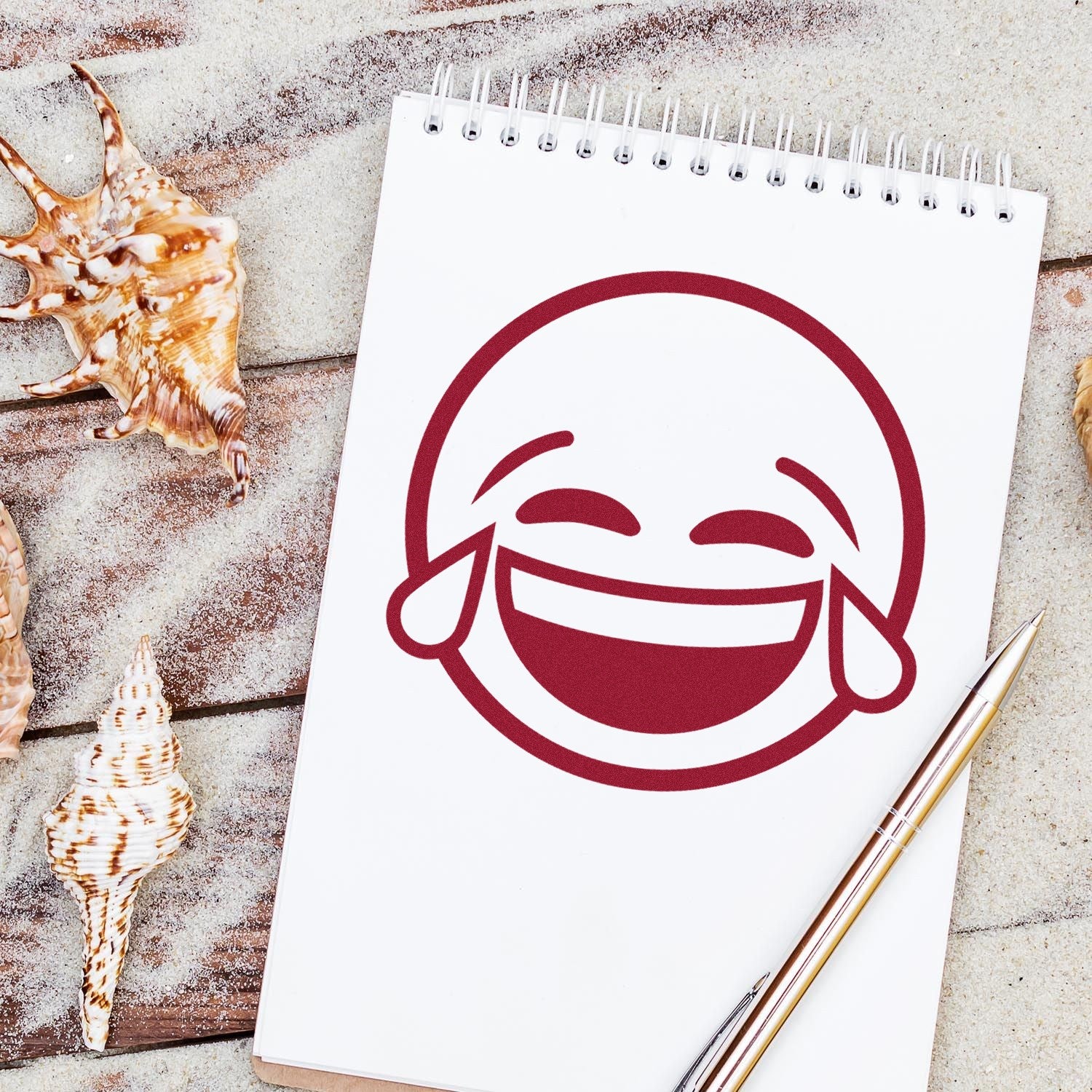 Self-Inking Tearful Giggles Emoji Stamp on a notepad, featuring a laughing emoji with tears. Perfect for adding fun to notes and crafts.