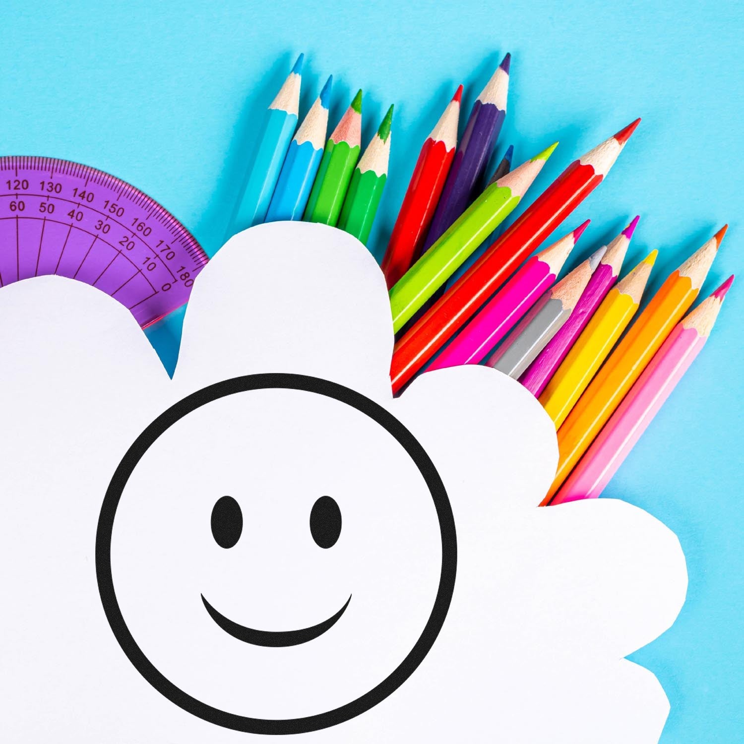 Self-Inking Simple Smiley Emoji Stamp on a cloud-shaped paper, surrounded by colorful pencils and a purple protractor, against a blue background. Perfect for adding fun to crafts and documents.