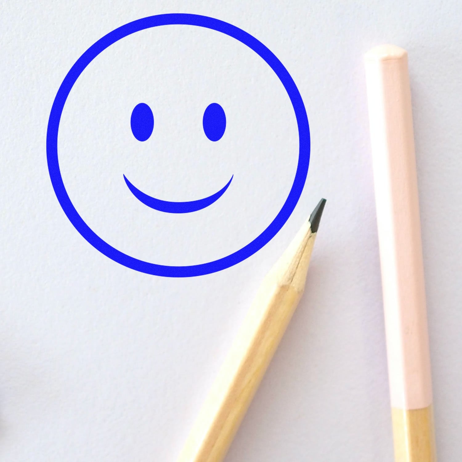 Wood Handle Simple Smiley Emoji Rubber Stamp on white paper, featuring a blue smiley face imprint. Includes a wooden handle and rubber stamp design, perfect for crafting and stationery.