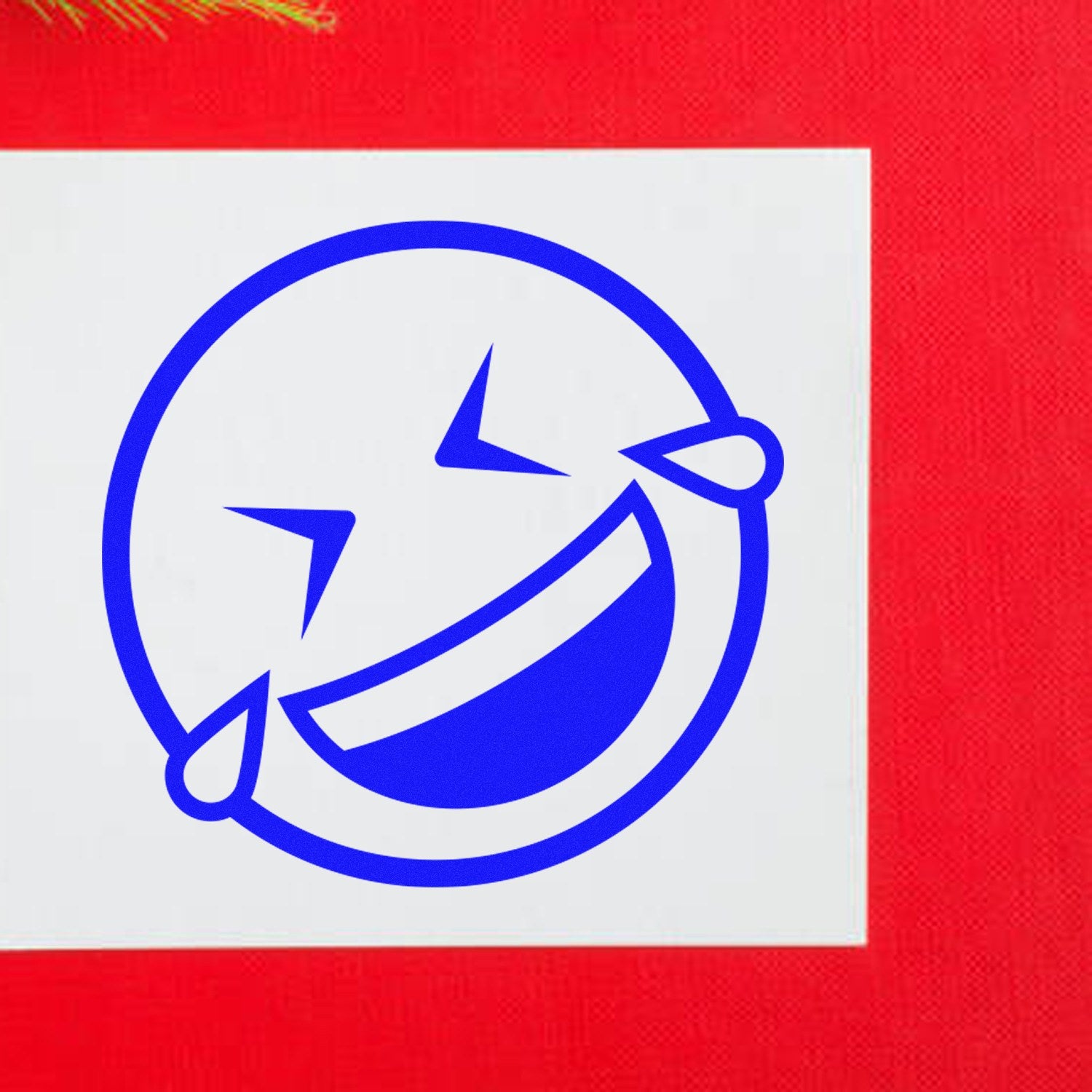 Wood Handle Laugh Riot Smiley Rubber Stamp imprint on white paper, featuring a blue laughing smiley face with tears, set against a vibrant red background.