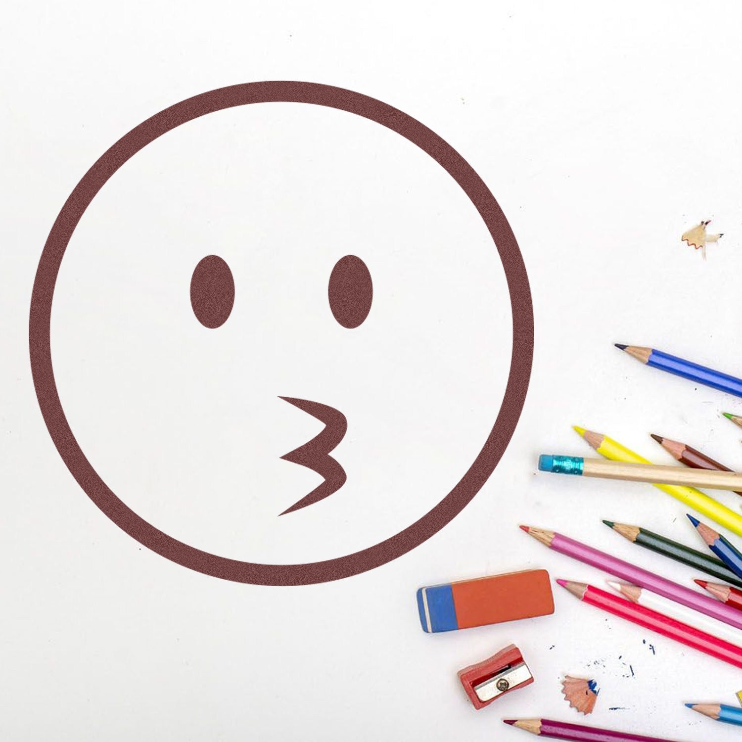 Wood Handle Whistling Wil Emojicons Rubber Stamp on white paper, surrounded by colorful pencils and erasers, showcasing a playful whistling face design. Perfect for creative projects and crafts.