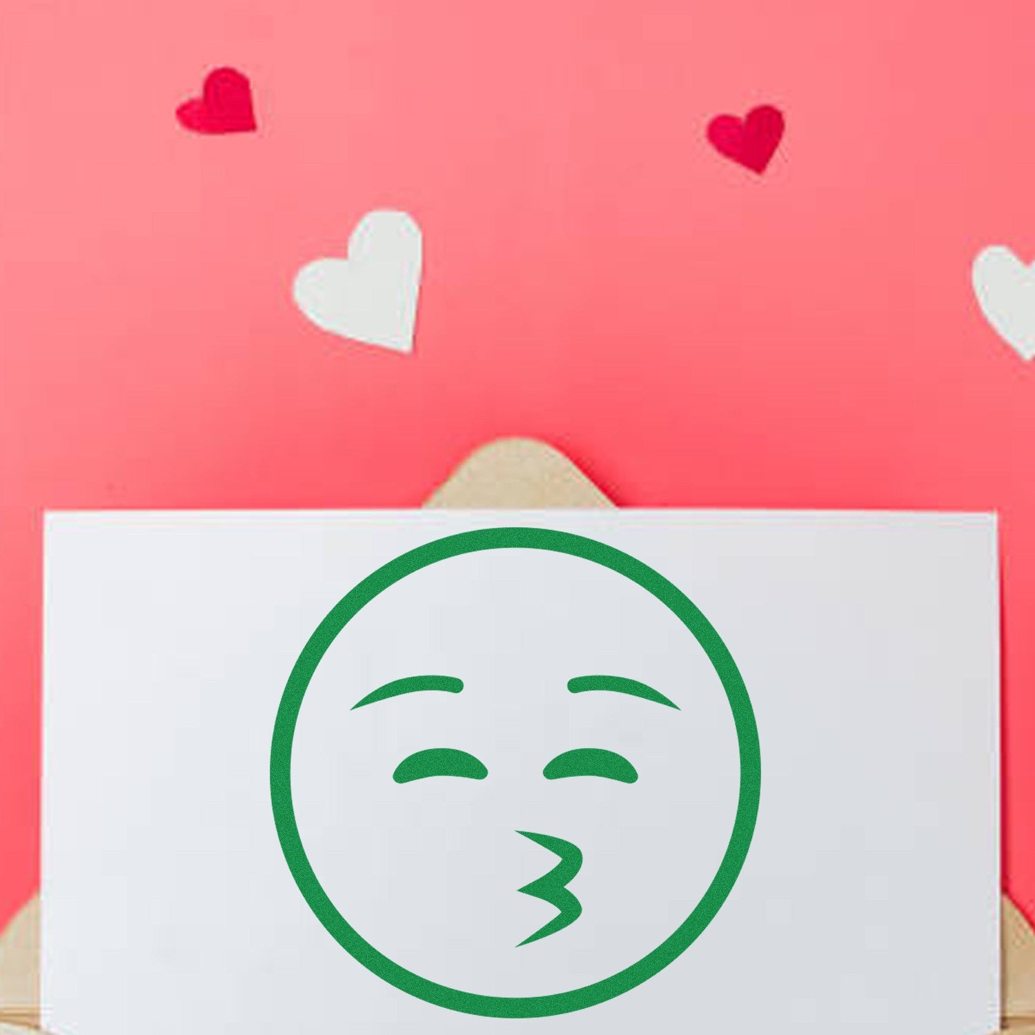 Self-Inking Whistling Wanderer Emoji Stamp on a card with a pink background and heart decorations, showcasing a green whistling emoji design. Perfect for adding fun to your stationery.