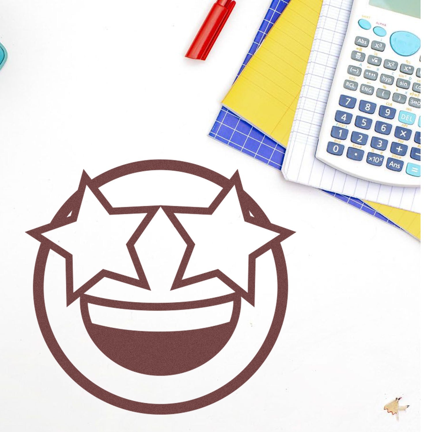 Self-Inking Starry Eyed Emotes Stamp on a desk with stationery, featuring a smiling face with starry eyes. Perfect for adding fun, expressive touches to your projects.