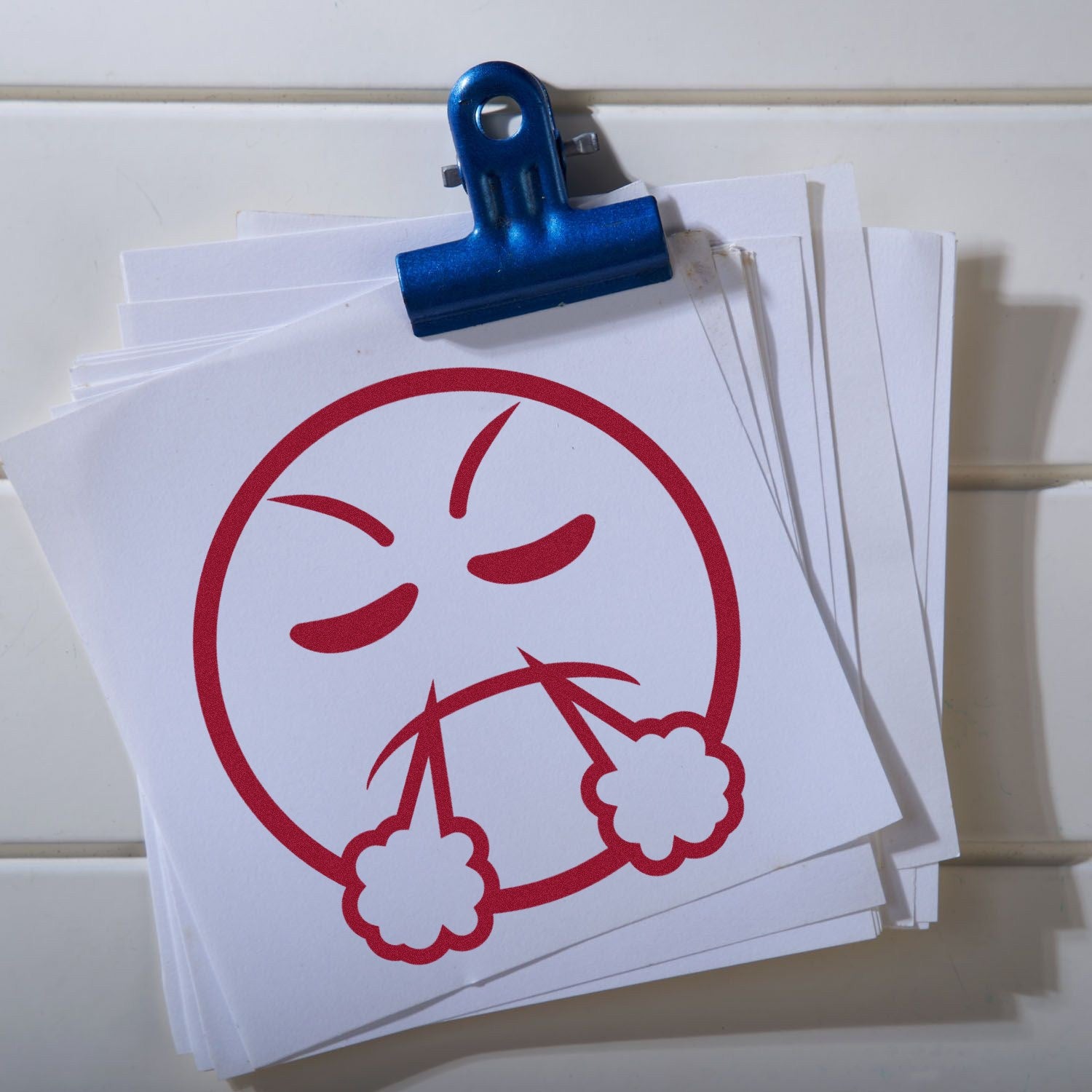 Wood Handle Steamy Sam Emoticon Rubber Stamp with a red angry face blowing steam, displayed on white paper sheets clipped together.