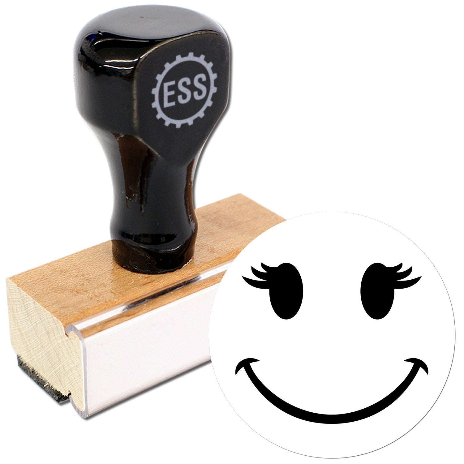 Wood Handle Fluttery Lashes Emoji Rubber Stamp featuring a black handle with ESS logo, mounted on a wooden base, and a stamp design of a smiling face with fluttery lashes.