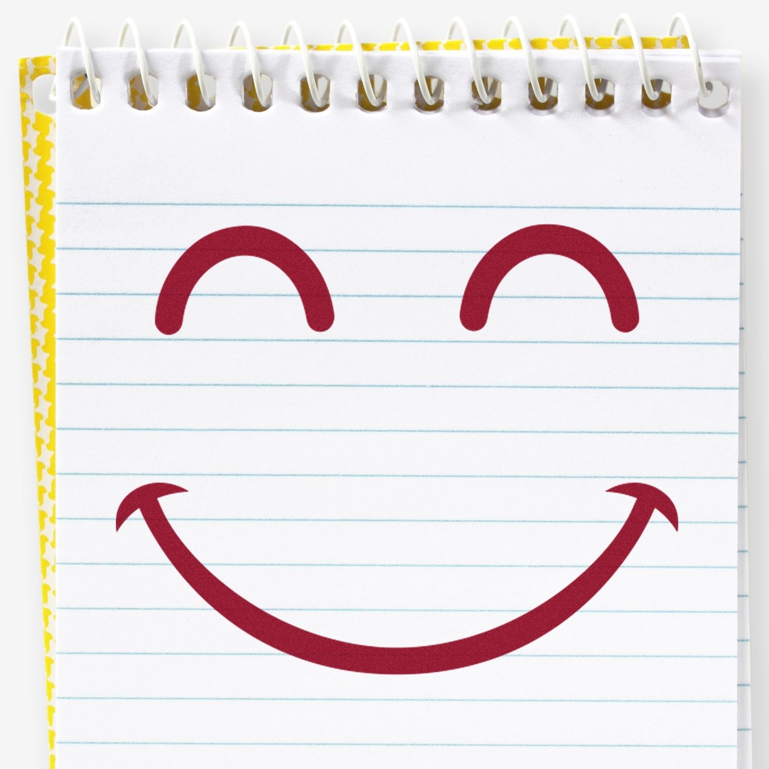 Wood Handle Giggly Smiley Emoji Rubber Stamp on a spiral notebook, featuring a cheerful red smiley face design. Perfect for adding a playful touch to notes and crafts.