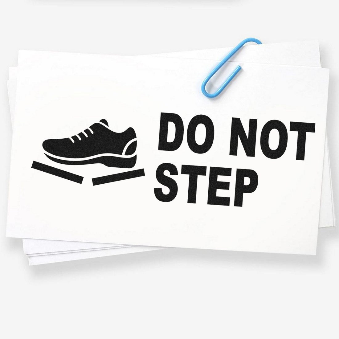 Self-Inking Handle With Care Do Not Step Stamp featuring a shoe icon and bold text on a white background, ideal for marking packages and fragile items.