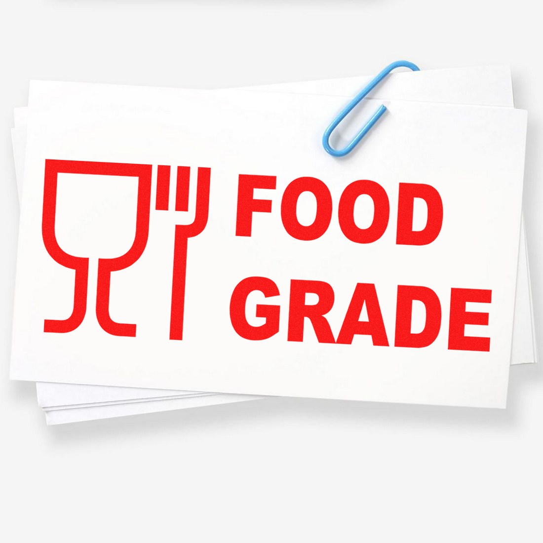 PSI Pre-Inked Certified Food Grade Stamp in use, displaying bold red Food Grade text with a fork and cup icon on white paper, secured with a blue paperclip.