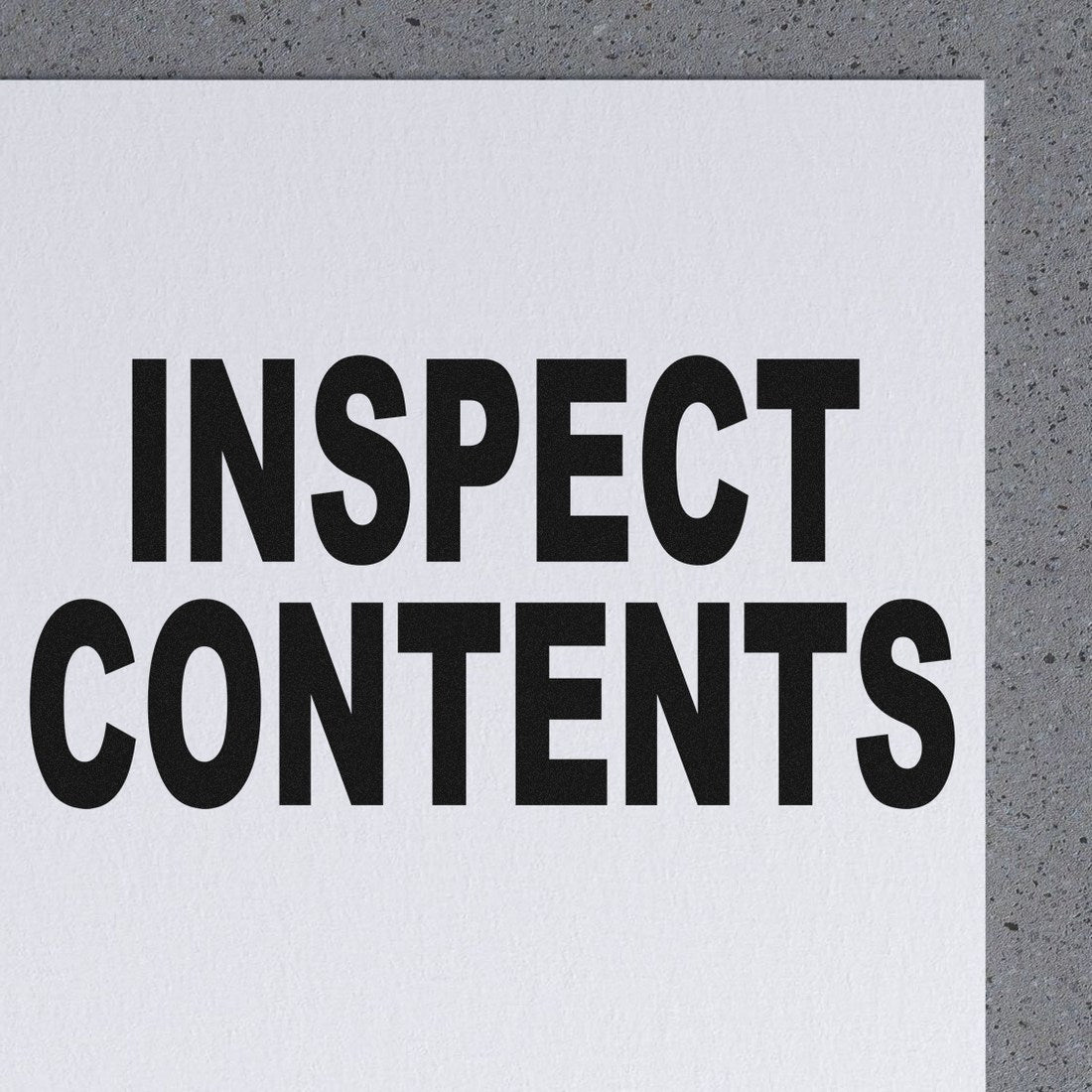 PSI Pre-Inked Inspect Contents Stamp imprint on white paper, showcasing bold black text 'INSPECT CONTENTS' for clear, professional marking. Ideal for efficient package inspection.