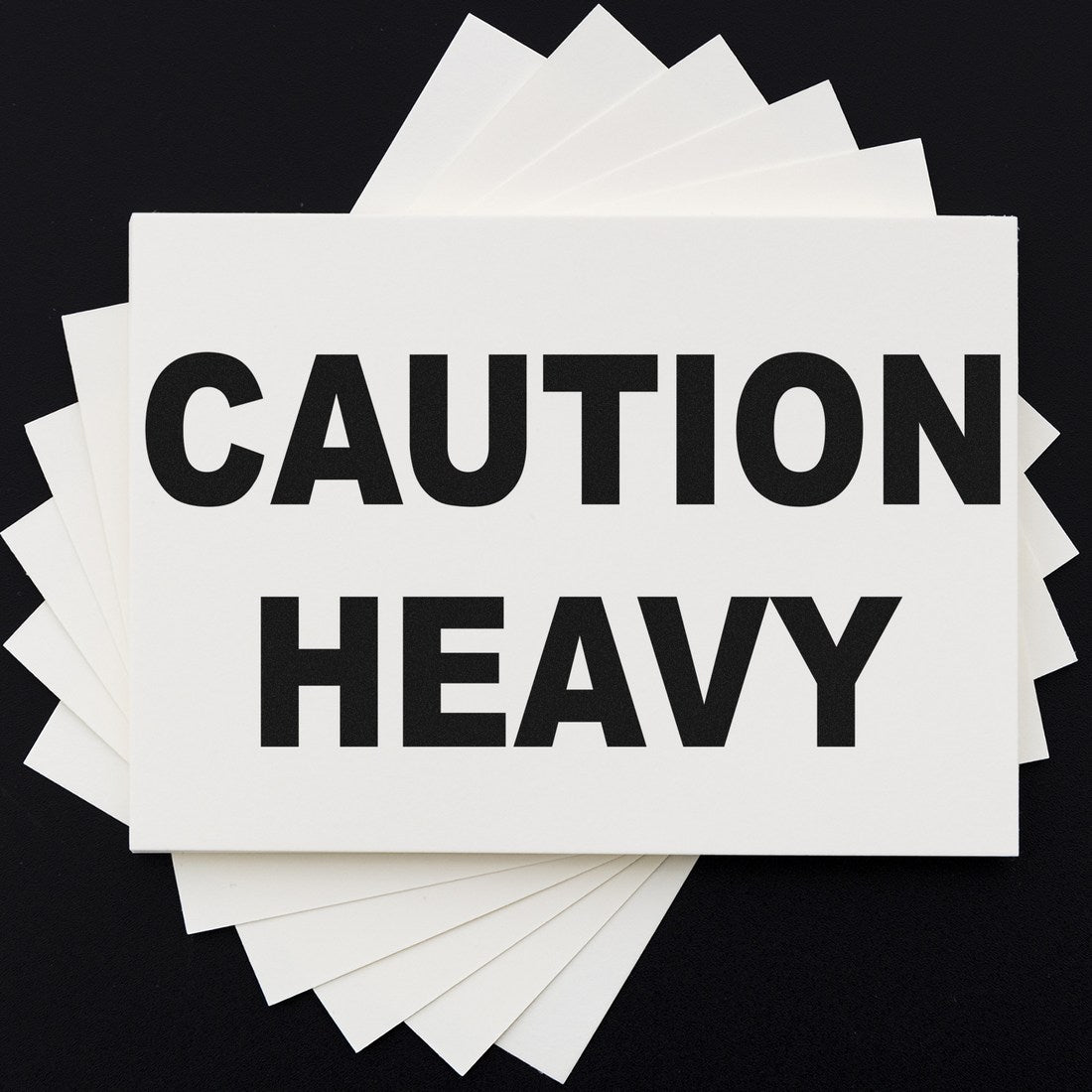 Image of the Slim Pre-Inked Heavy Caution Stamp, featuring bold black text CAUTION HEAVY on a white background, ideal for marking heavy items.