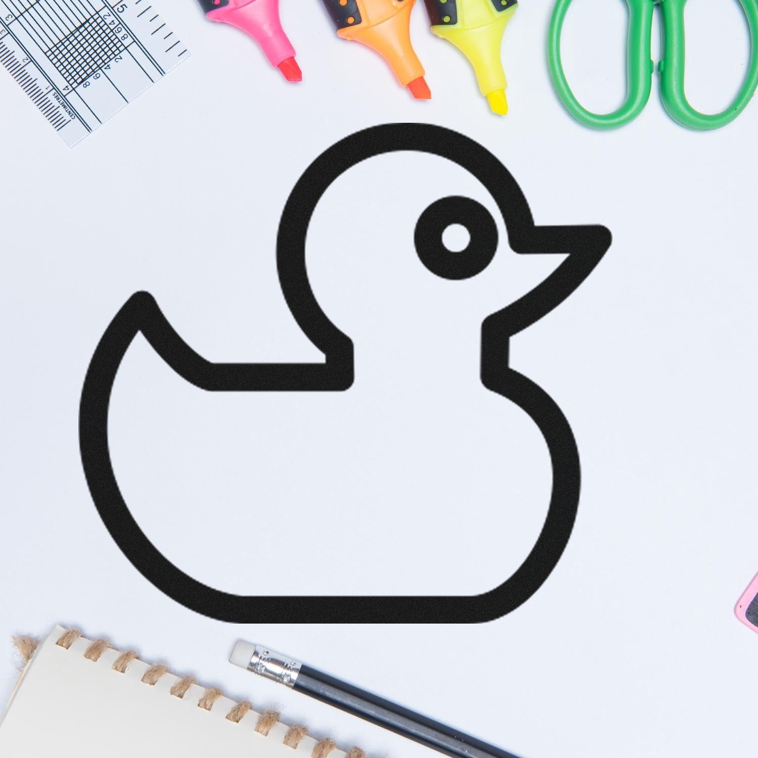 Wood Handle Ducky Delight Repeat Customer Rubber Stamp on a desk with stationery items, featuring a cute duck outline design. Perfect for adding charm to your projects.