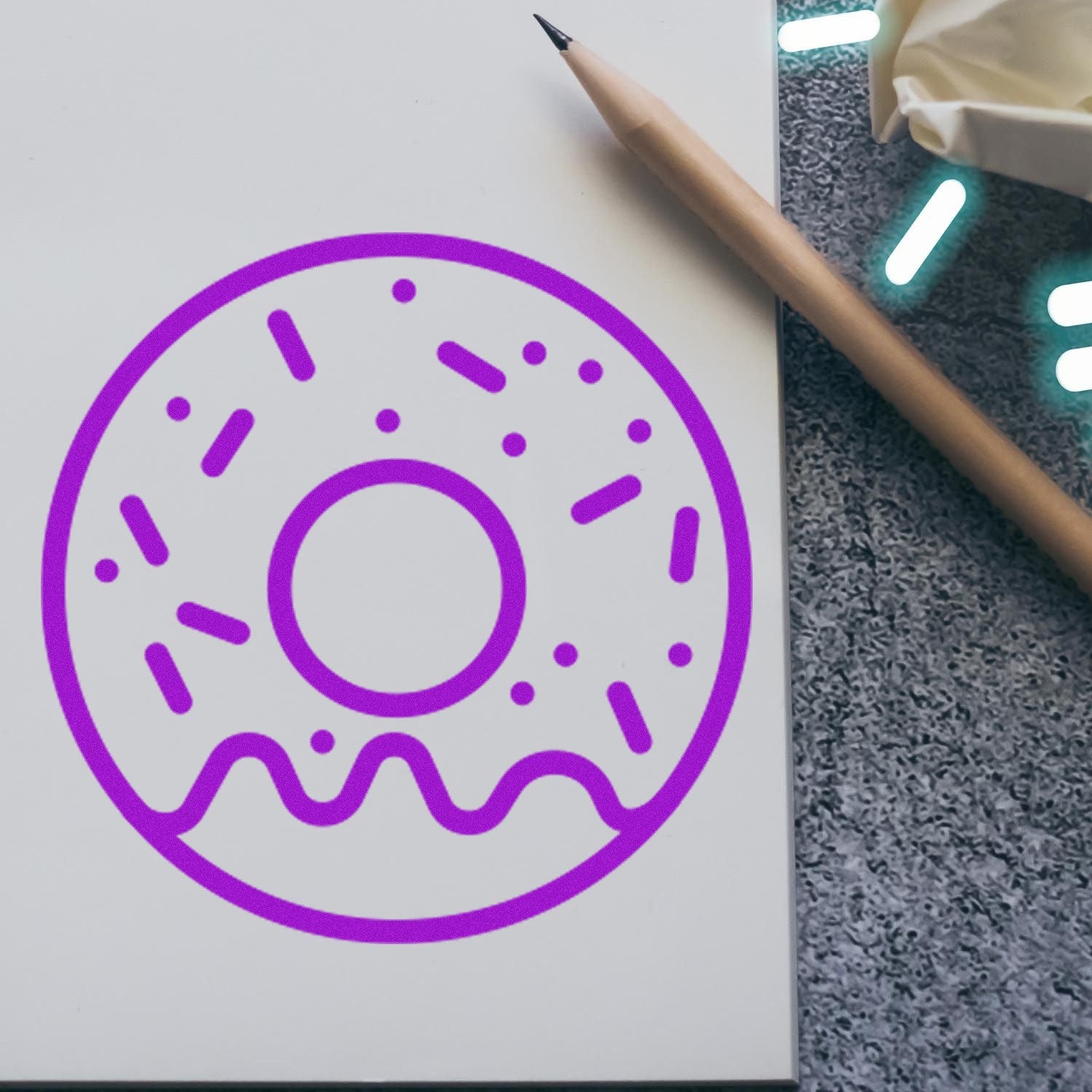 Self-Inking Doughnut Delight Repeat Customer Stamp with purple doughnut design, shown on paper with a pencil nearby. Perfect for adding a fun touch to customer loyalty programs.