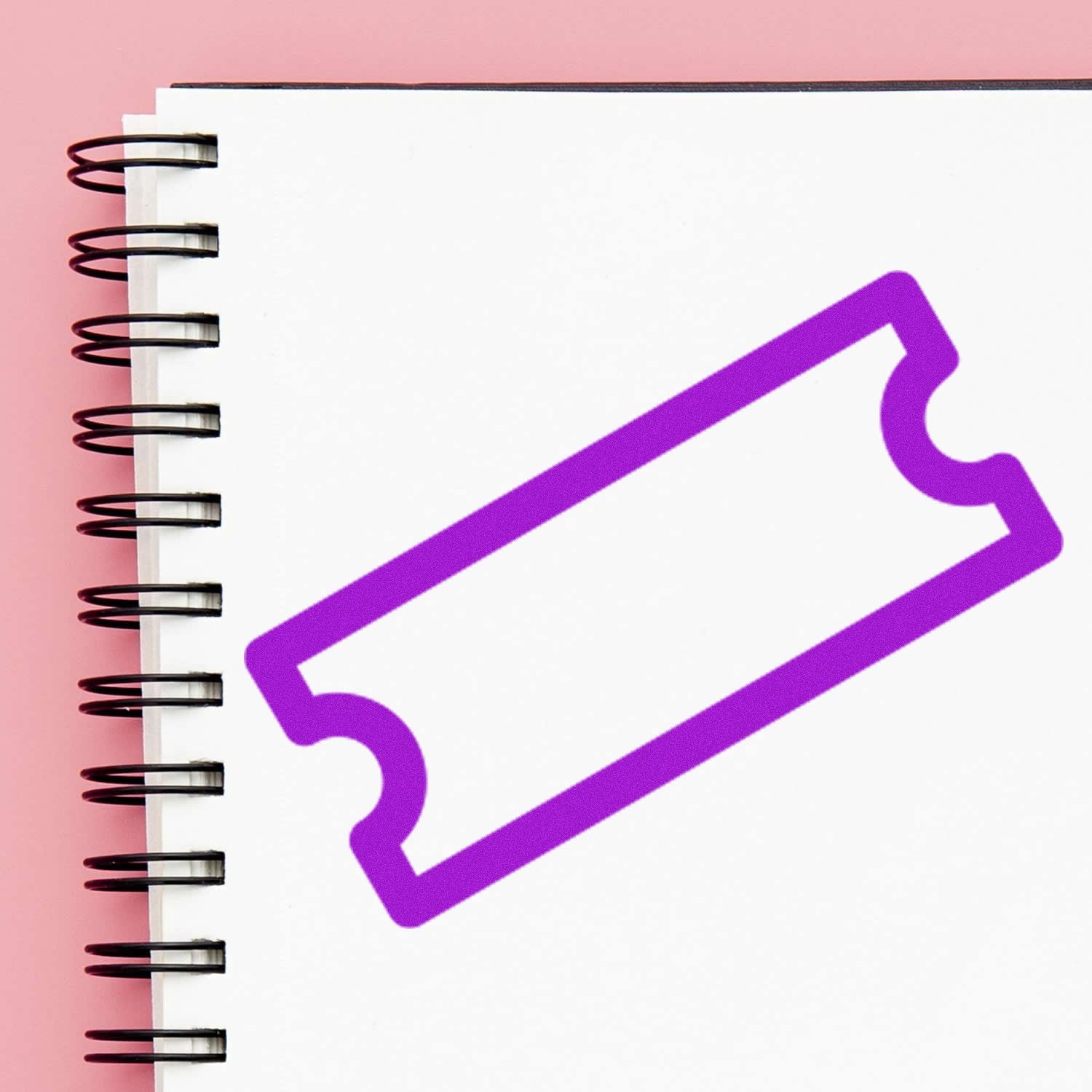 Self-Inking Ticket To Rewards Stamp on a spiral notebook, featuring a purple ticket design, ideal for teachers and reward systems.