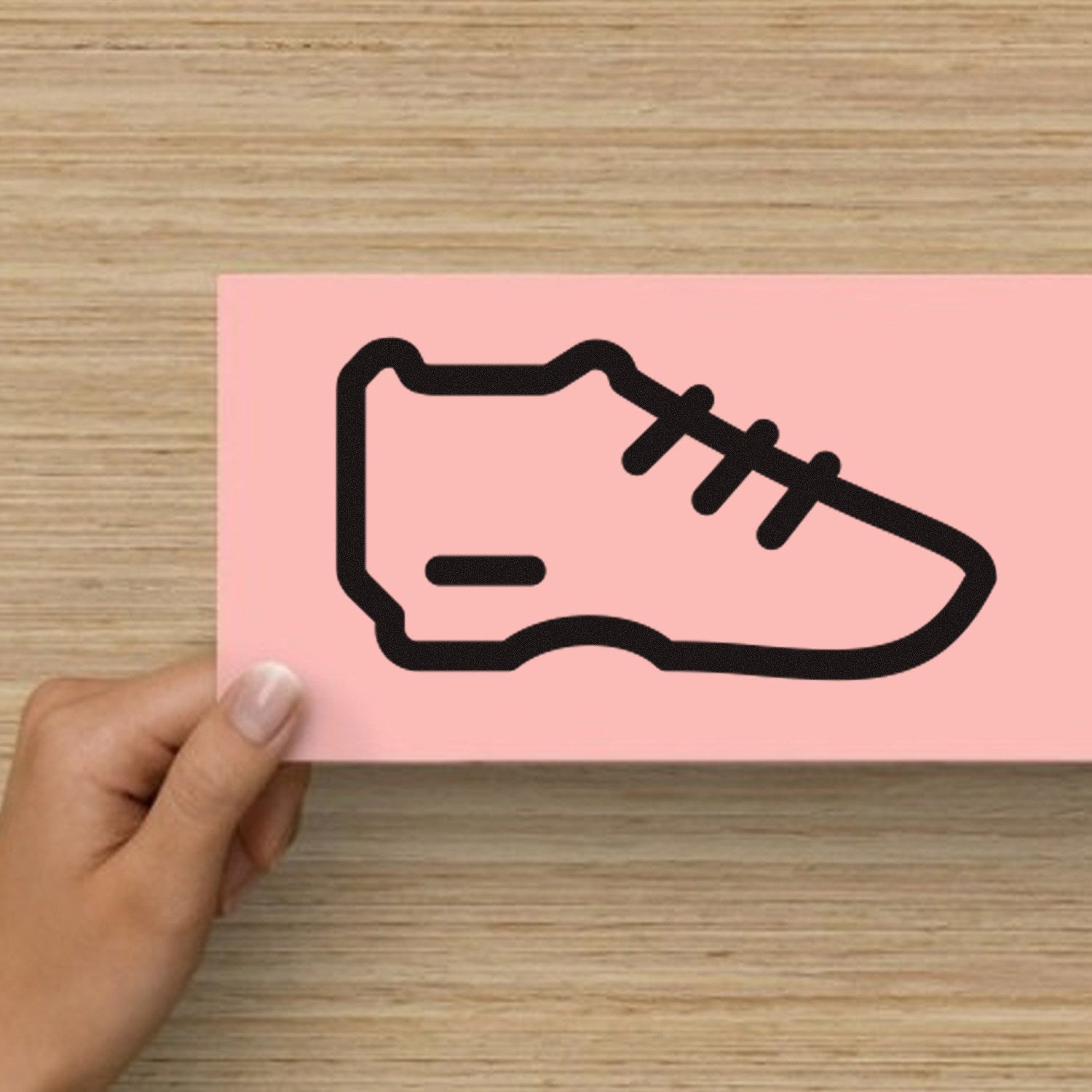 Wood Handle Sneaker Reward Rubber Stamp featuring a sneaker design on a pink background, held by a hand. Perfect for crafting and rewarding.