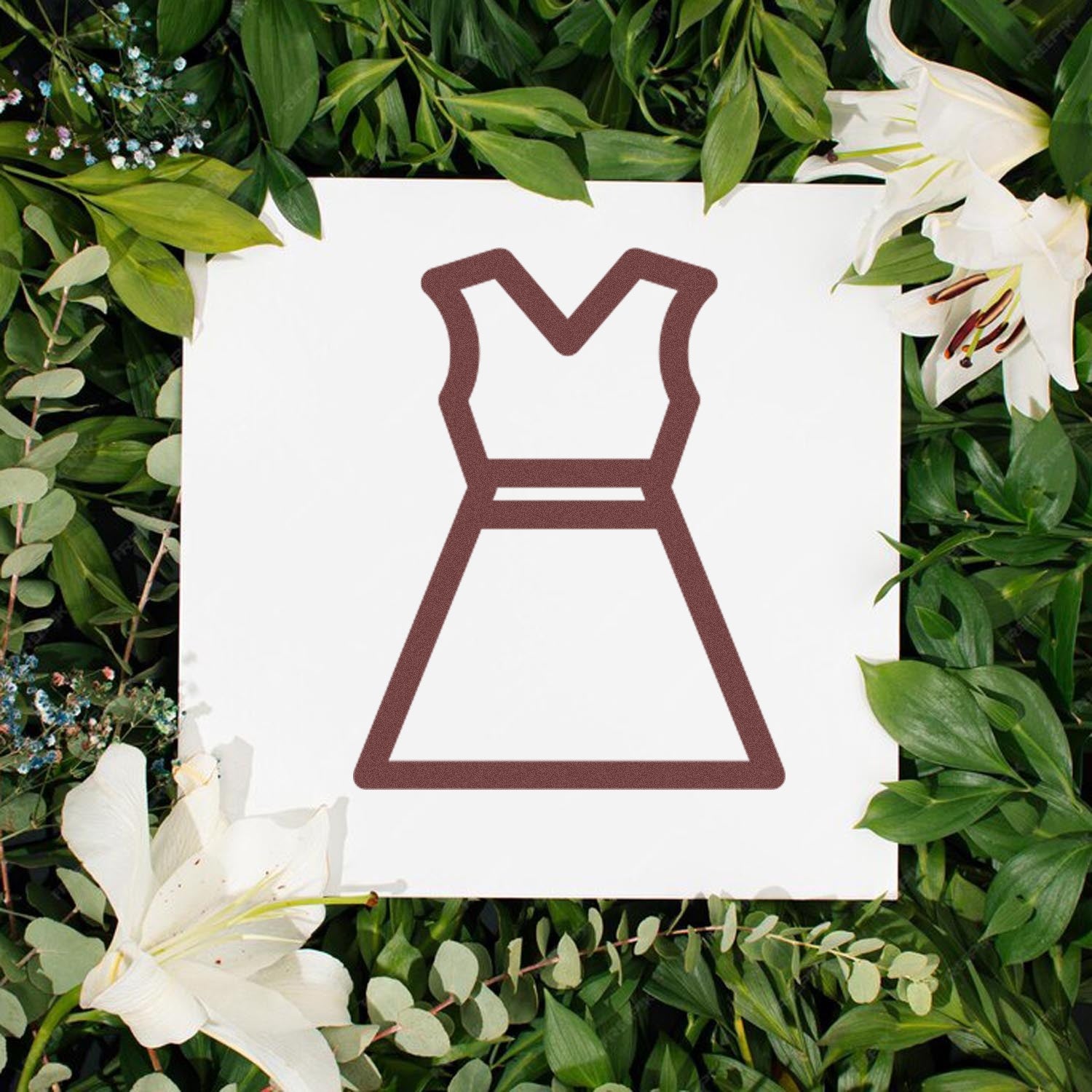 Self-Inking Clothing Punch Card Stamp on a white background with a dress outline, surrounded by green leaves and white lilies. Perfect for marking clothing with ease and style.