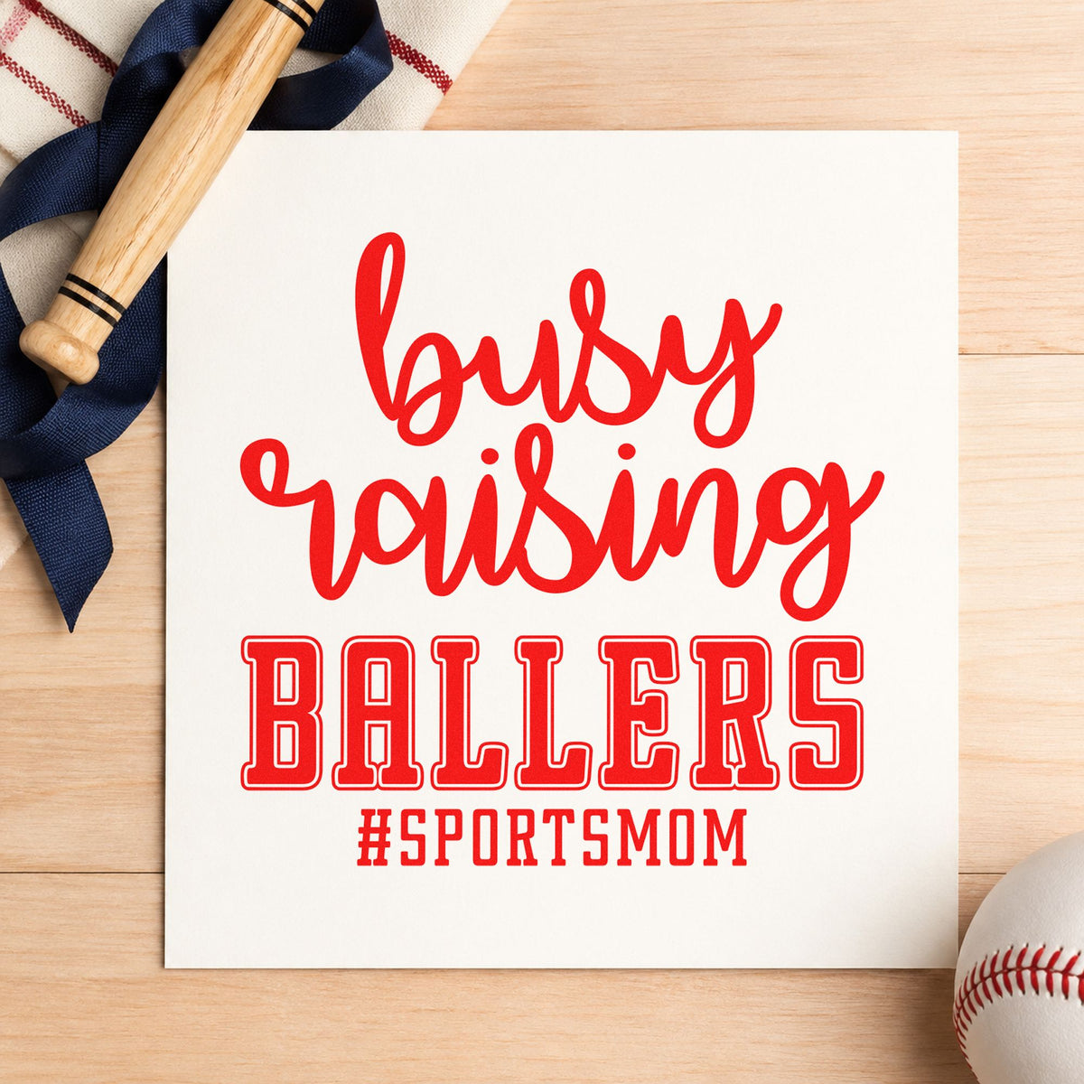 Busy Raising Ballers rubber stamp shown in red ink, stamped for projects such as mother's day cards.