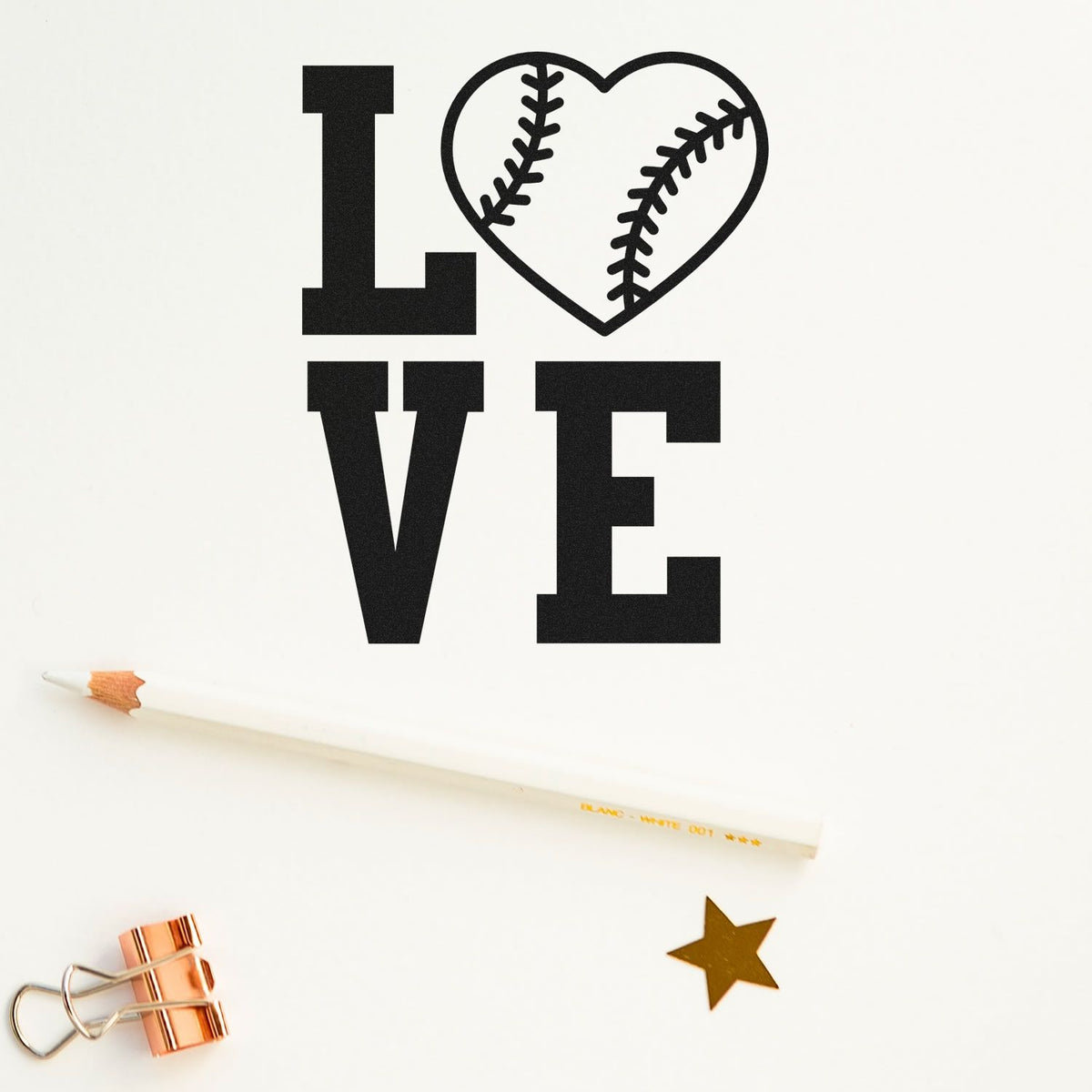 Black LOVE rubber stamp with a baseball heart, gold star seal, pencil and binder clip on white background.