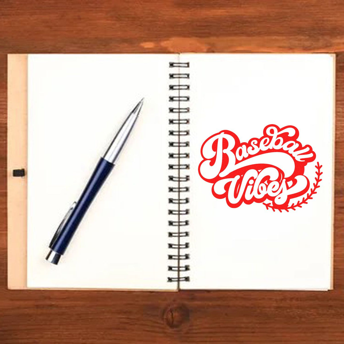 Open spiral notebook with blue pen and red Baseball Vibes stamp seal on white pages