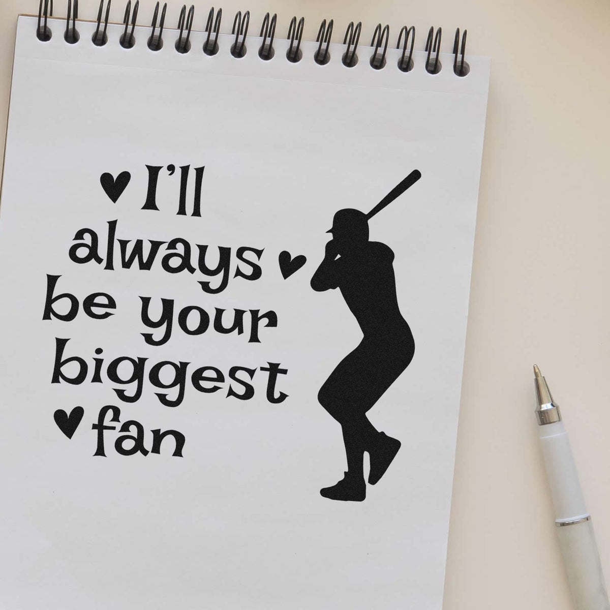 Black stamp-style baseball fan design on white spiral notebook: Ill always be your biggest fan with hearts and batter silhouette.