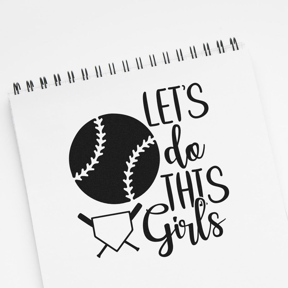 Black baseball-themed stamp seal with Lets do this girls on a white spiral notebook.
