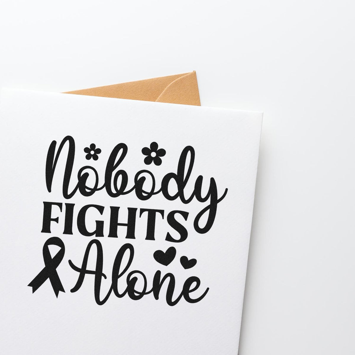 Black cancer awareness stamp or seal on white card with tan envelope, reading Nobody Fights Alone, ribbon, hearts and flowers.