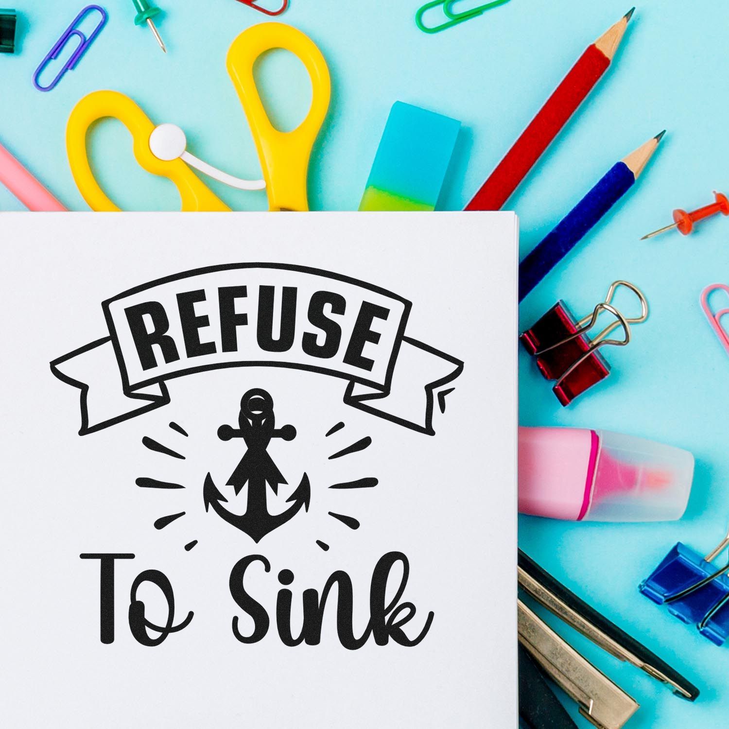 Black REFUSE To Sink anchor stamp and seal design on white paper, surrounded by colorful stationery on turquoise background.