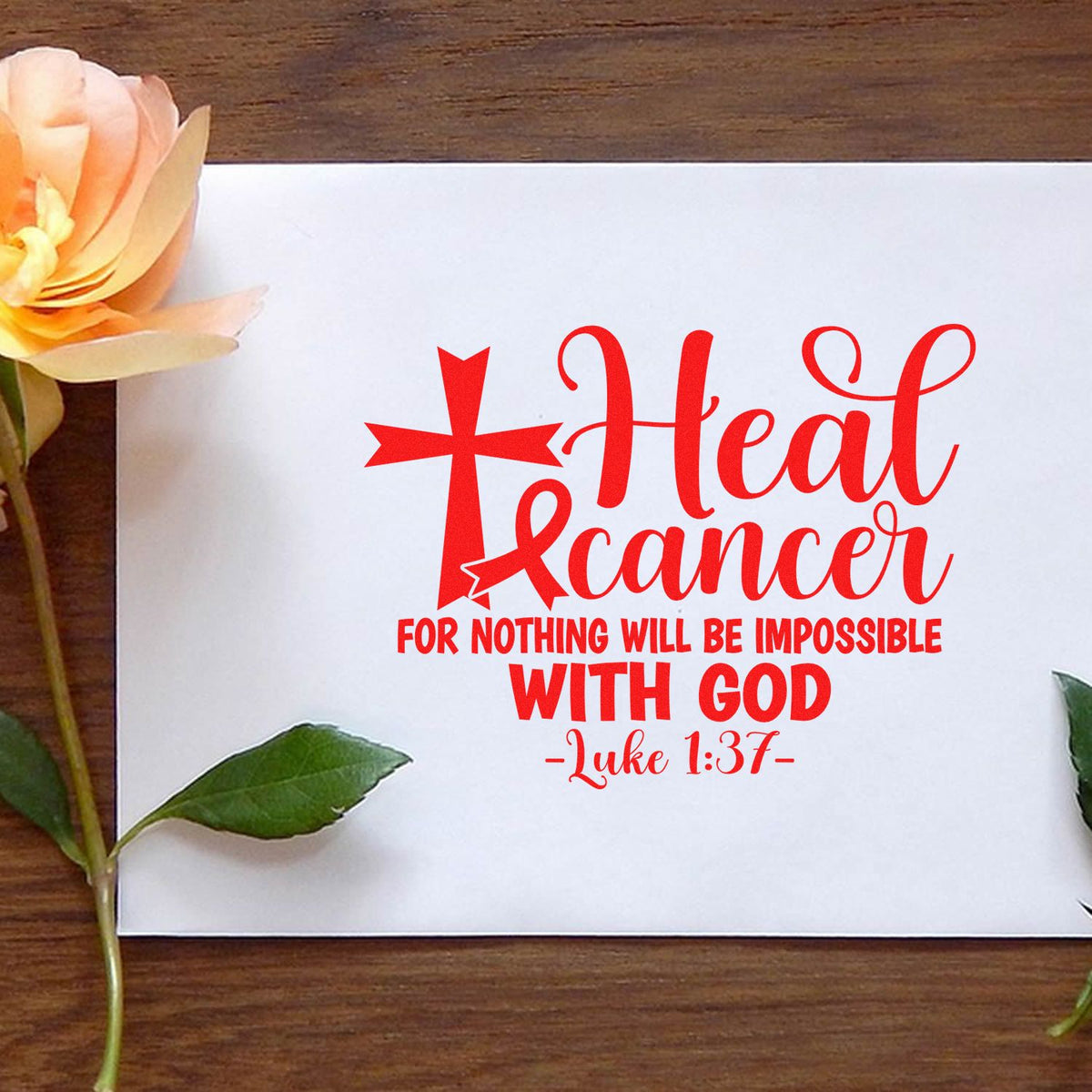 Red stamp seal with cross and cancer ribbon, reading Heal cancer with God and Luke 1:37 on a white card.