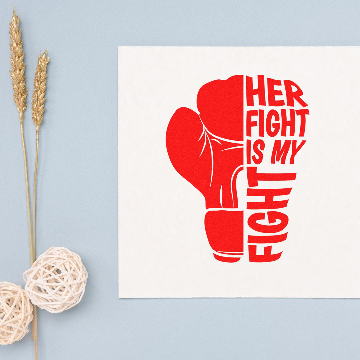 Red boxing glove stamp and seal with Her Fight Is My Fight on white card, beside gold wheat stems.