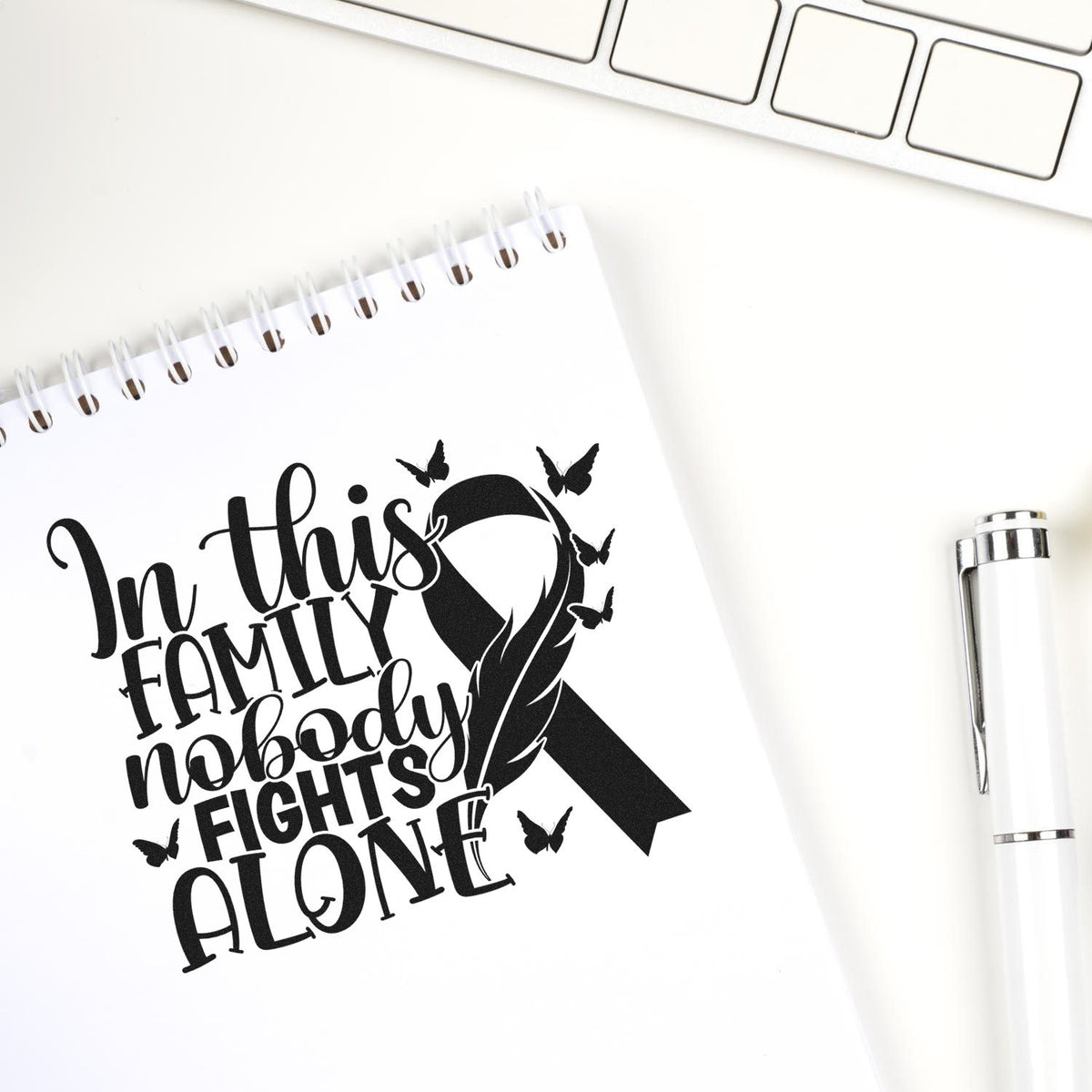 Black custom stamp seal design on white notebook with awareness ribbon, butterflies, and In this family nobody fights alone text.