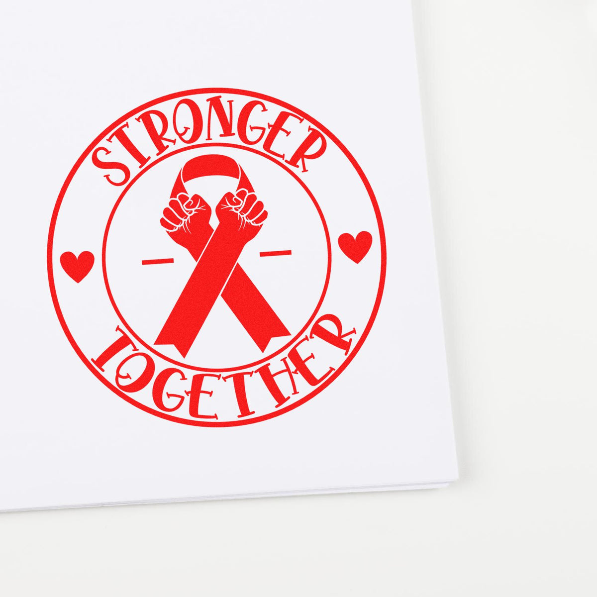 Red Stronger Together stamp seal with awareness ribbon and hearts on white paper.