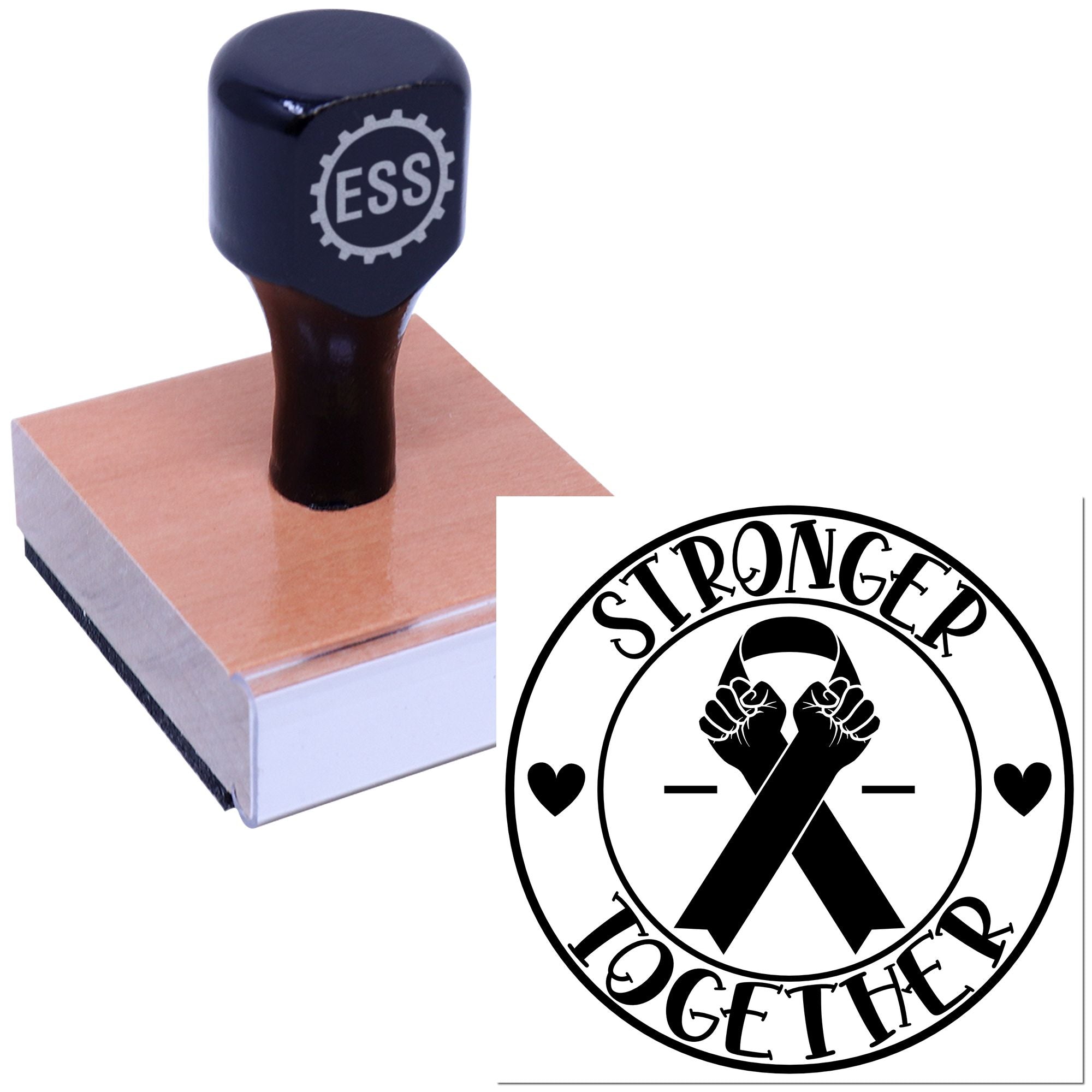 Black ESS rubber stamp on a wooden base beside a circular seal reading Stronger Together with ribboned fists and hearts.