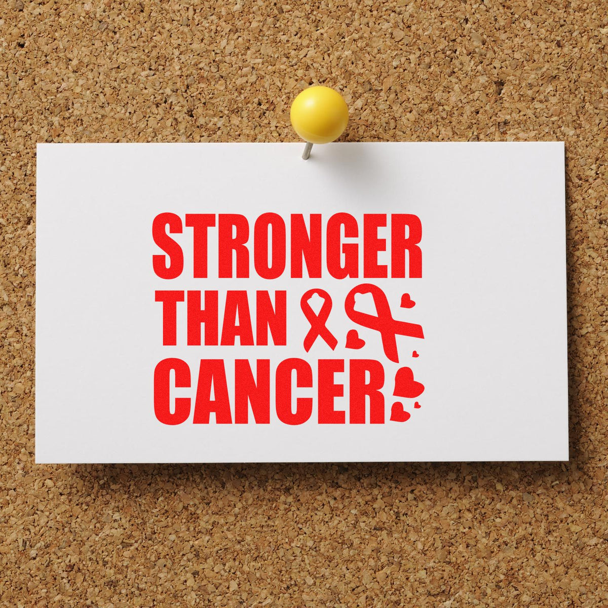 Cancer awareness stamp/seal on white card: red Stronger Than Cancer text, pink ribbon, yellow pushpin on corkboard.