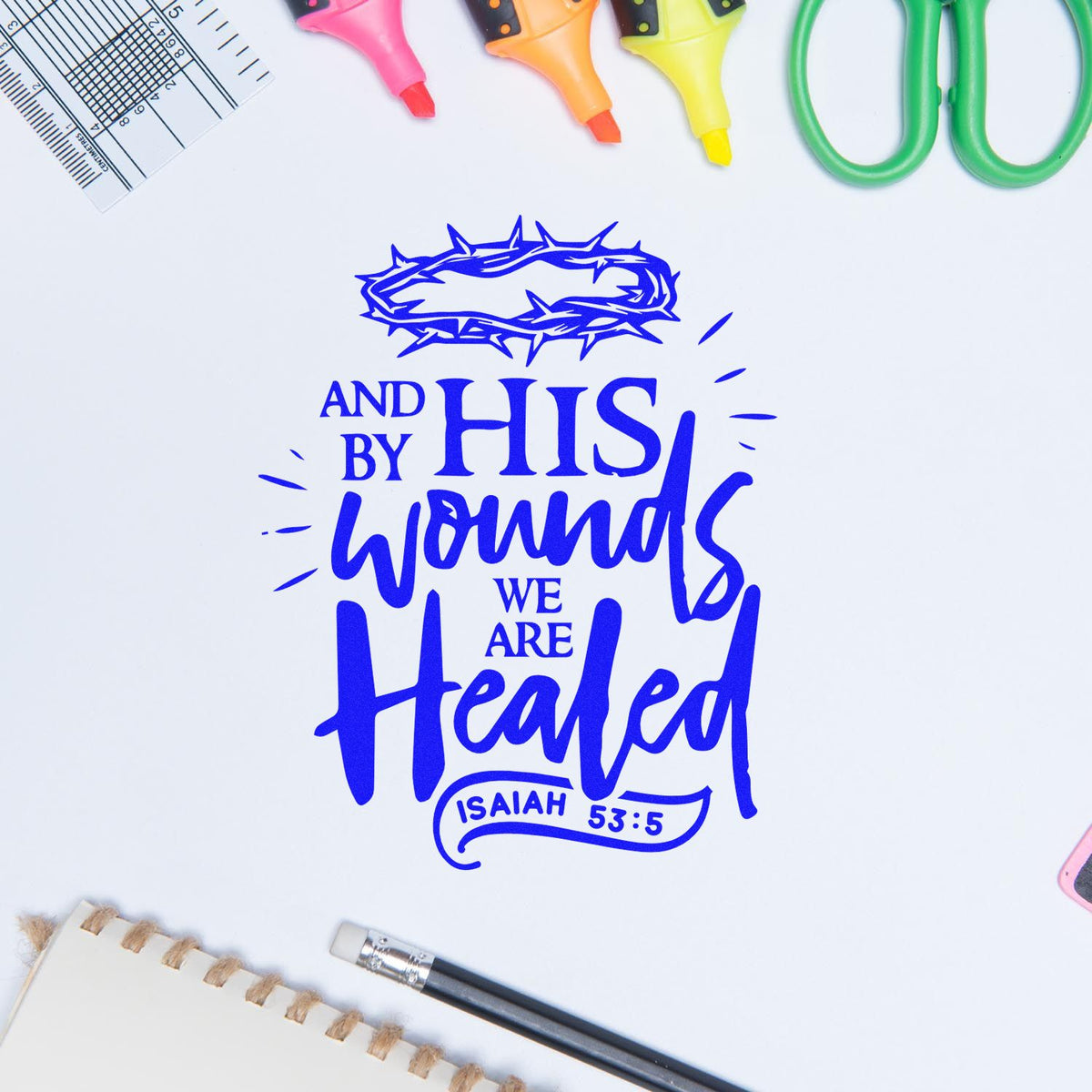 Blue stamp and seal design reading "And by His wounds we are healed," with thorn crown and colorful craft tools.