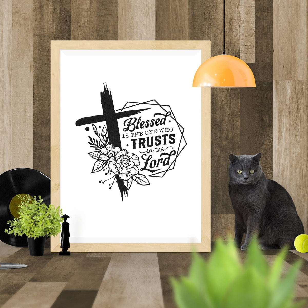 Black floral stamp-and-seal design with cross and Blessed is the one who trusts in the Lord in black on white, light wood frame.