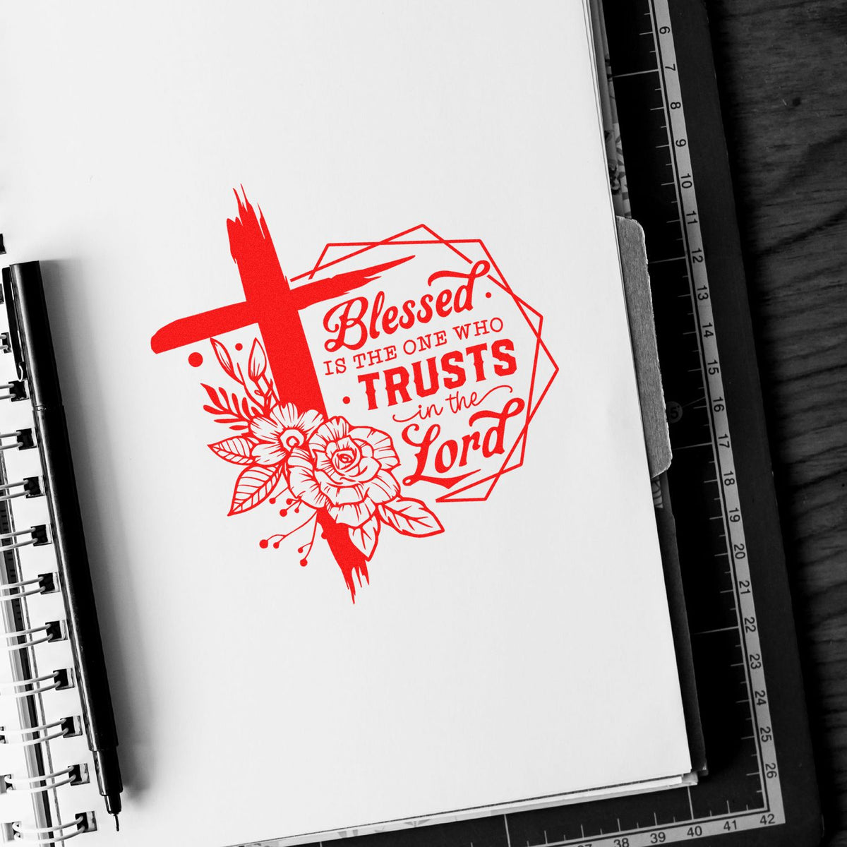 Red Christian stamp and seal design with cross, flowers, and quote Blessed is the one who trusts in the Lord on white paper.