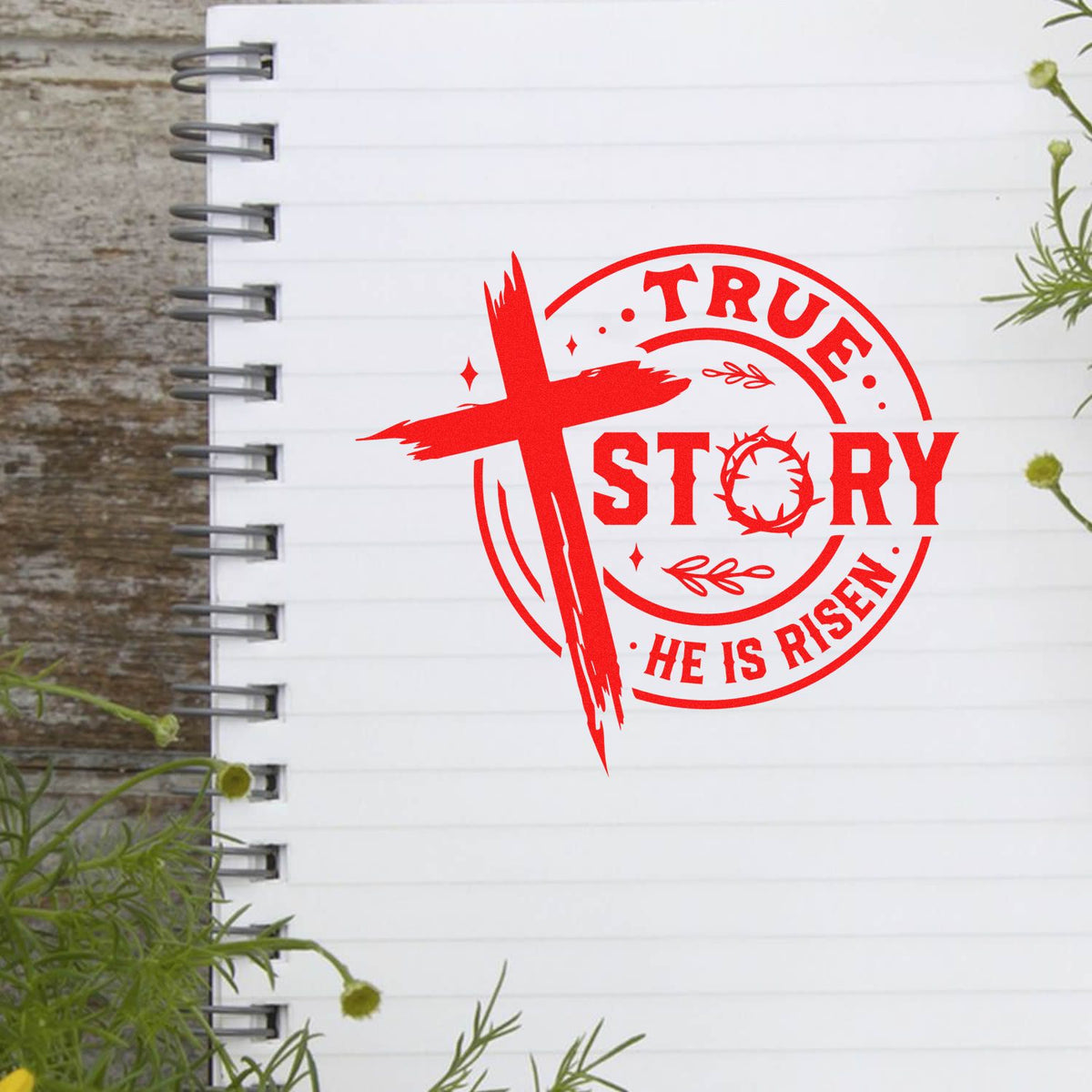 Red Christian stamp seal with cross, reading TRUE STORY and HE IS RISEN, on a white spiral notebook page.
