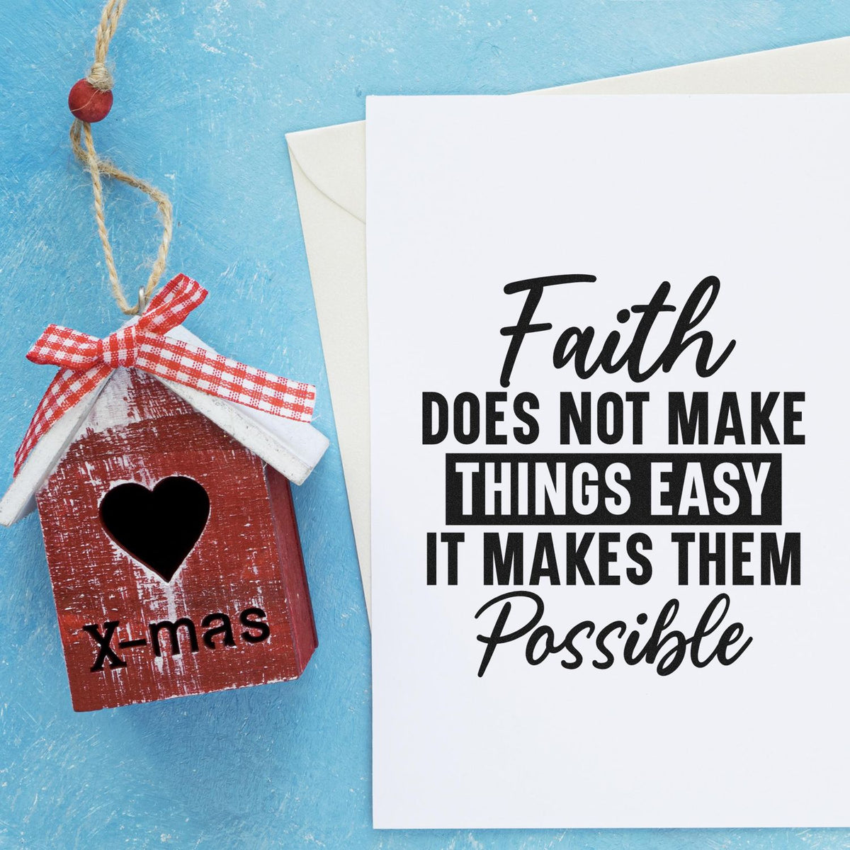 Rustic red birdhouse stamp-and-seal ornament with heart cutout, red gingham bow, beside white faith quote card on blue background.
