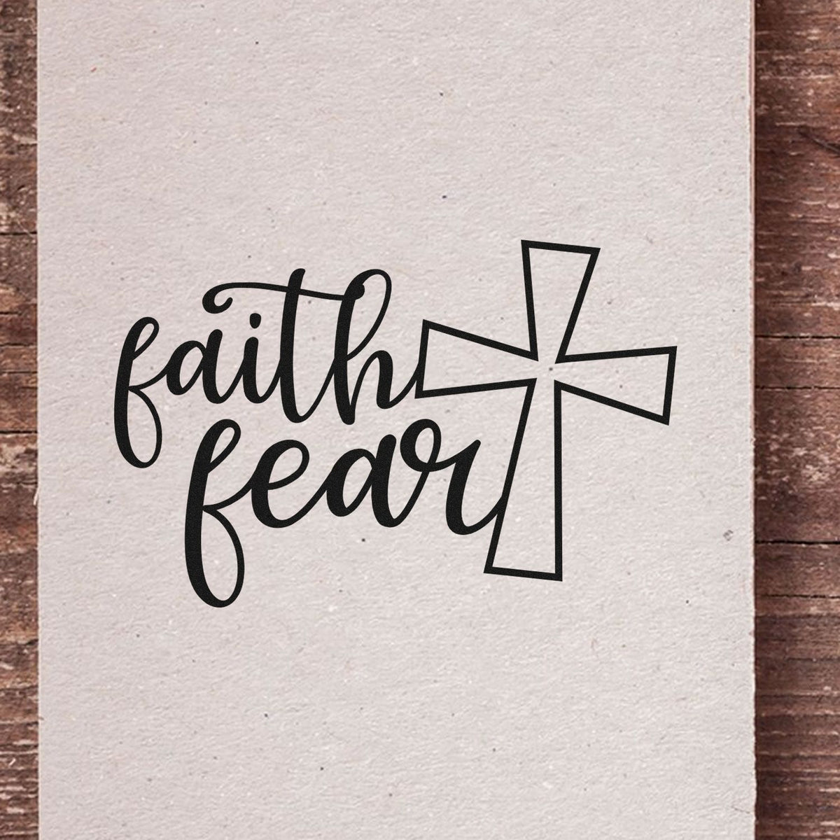 Black faith fear stamp and cross seal design on cream textured paper, with bold black lettering and outlined cross.