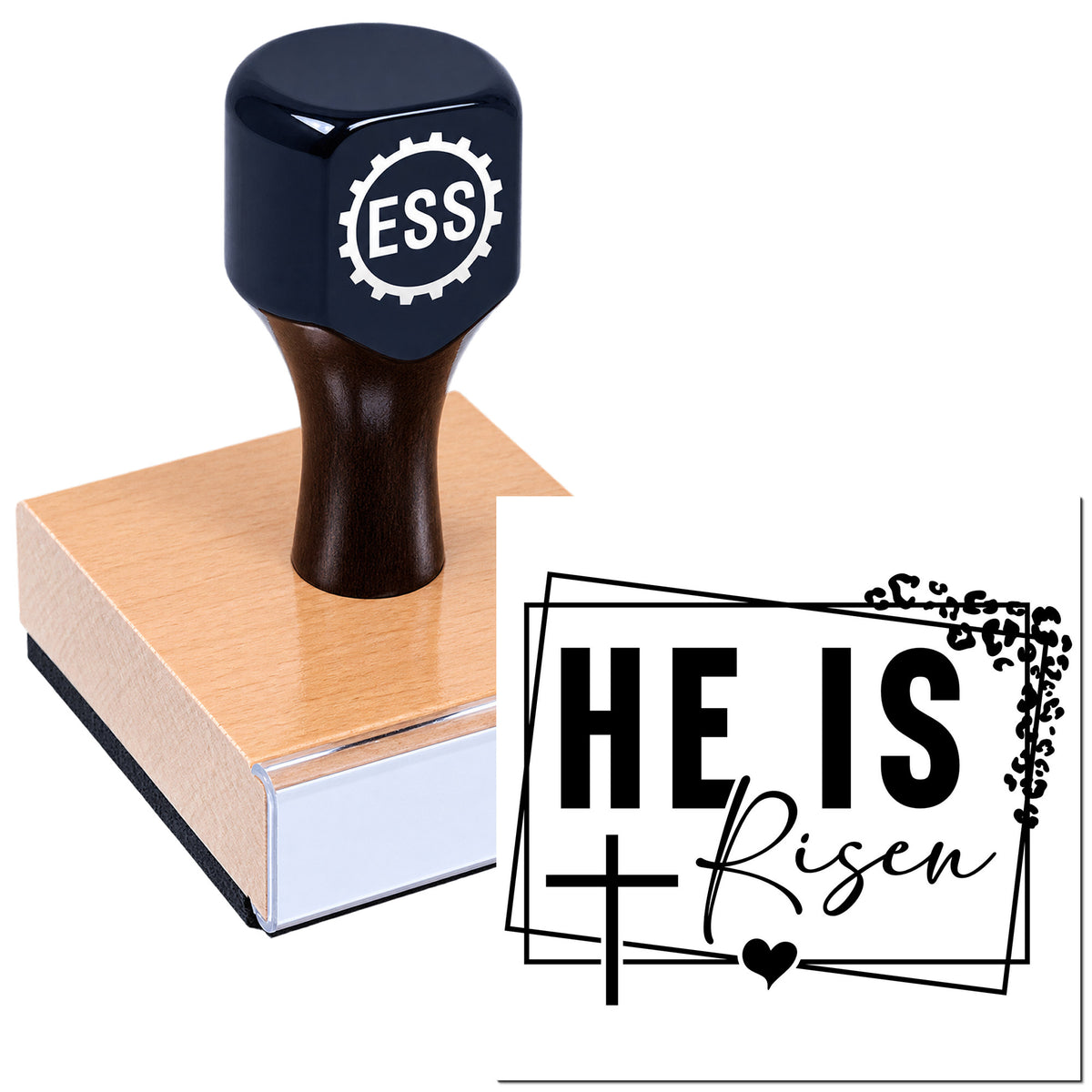 Dark navy stamp on a wooden block with a black "He Is Risen" seal, cross, heart, and decorative frame.
